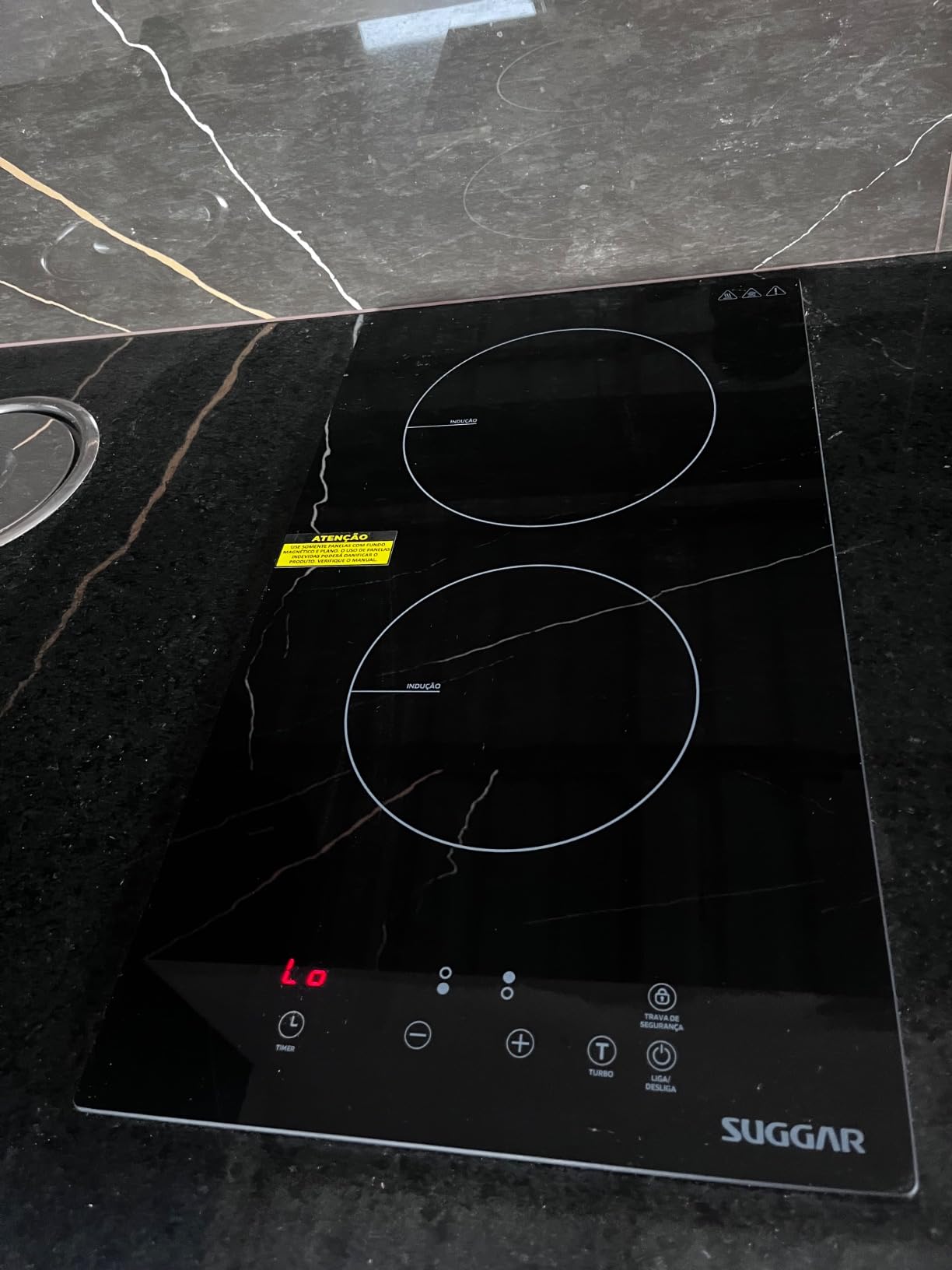 Cooktop de indução Suggar instalado em bancada de granito preto