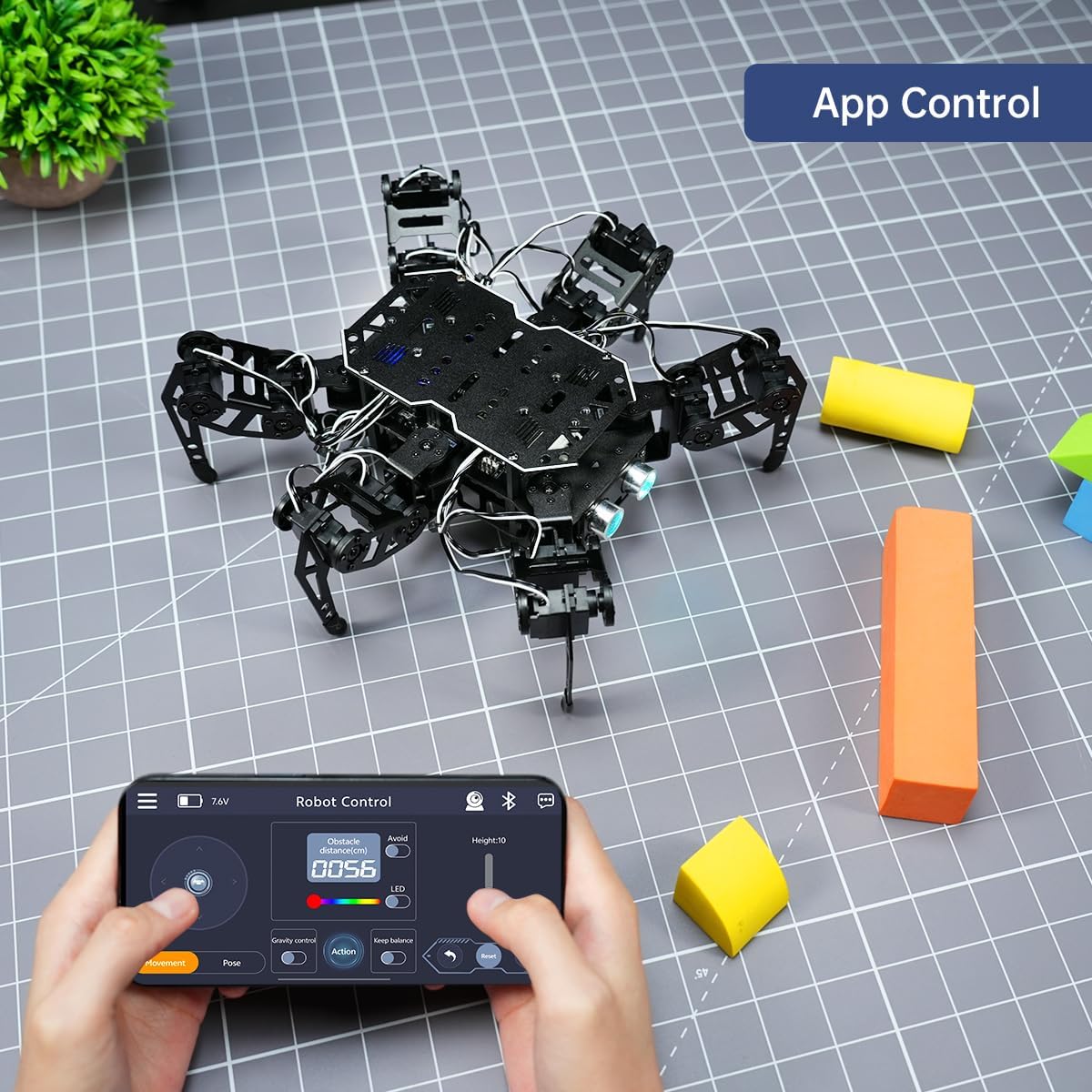 A person controlling the miniHexa robot using a smartphone app