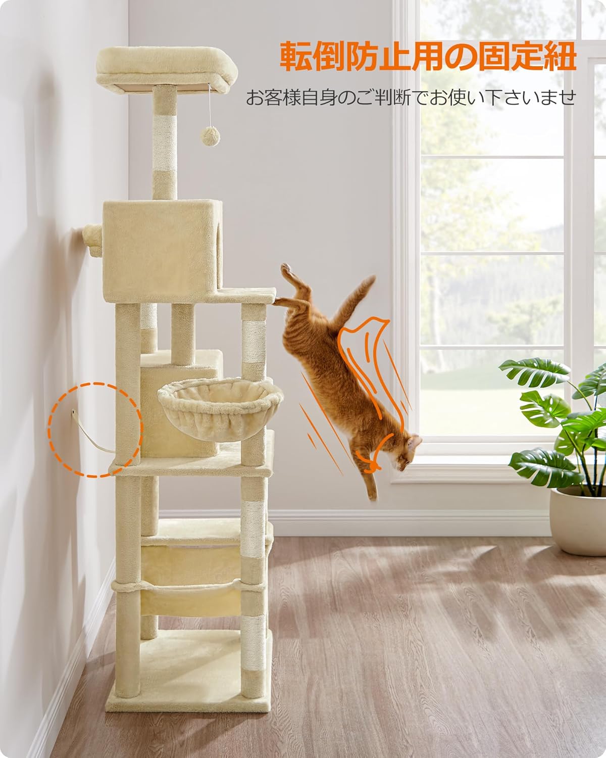 A cat jumping on the cat tower, with an arrow pointing to the anti-tip strap secured to the wall.