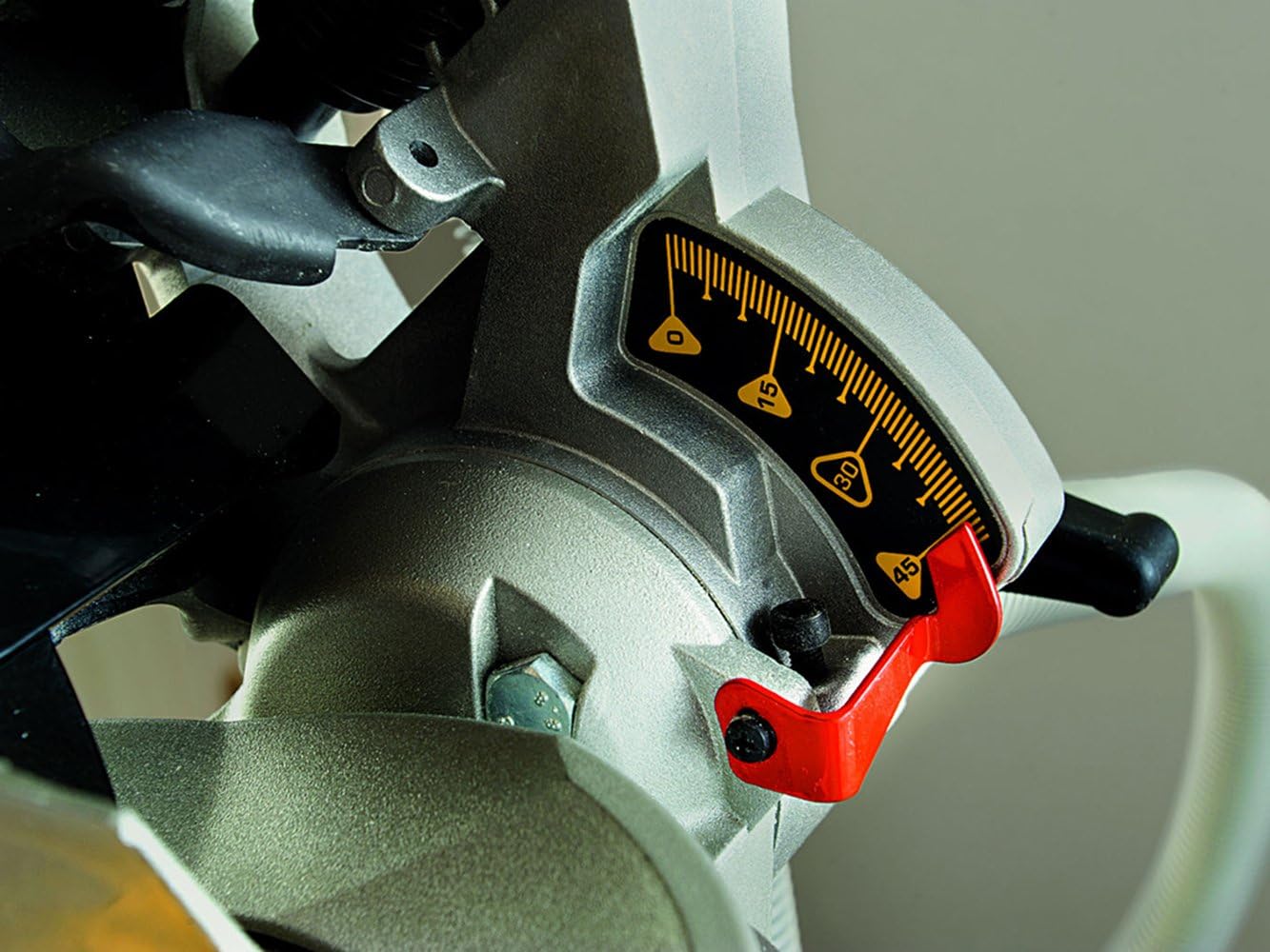 Close-up of the bevel angle adjustment scale and lever on the saw