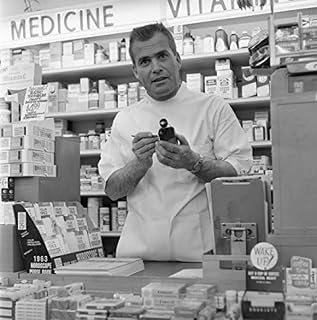 Posterazzi Pharmacist in drug store holding bottle and looking at camera Poster Print, (18 x 24)