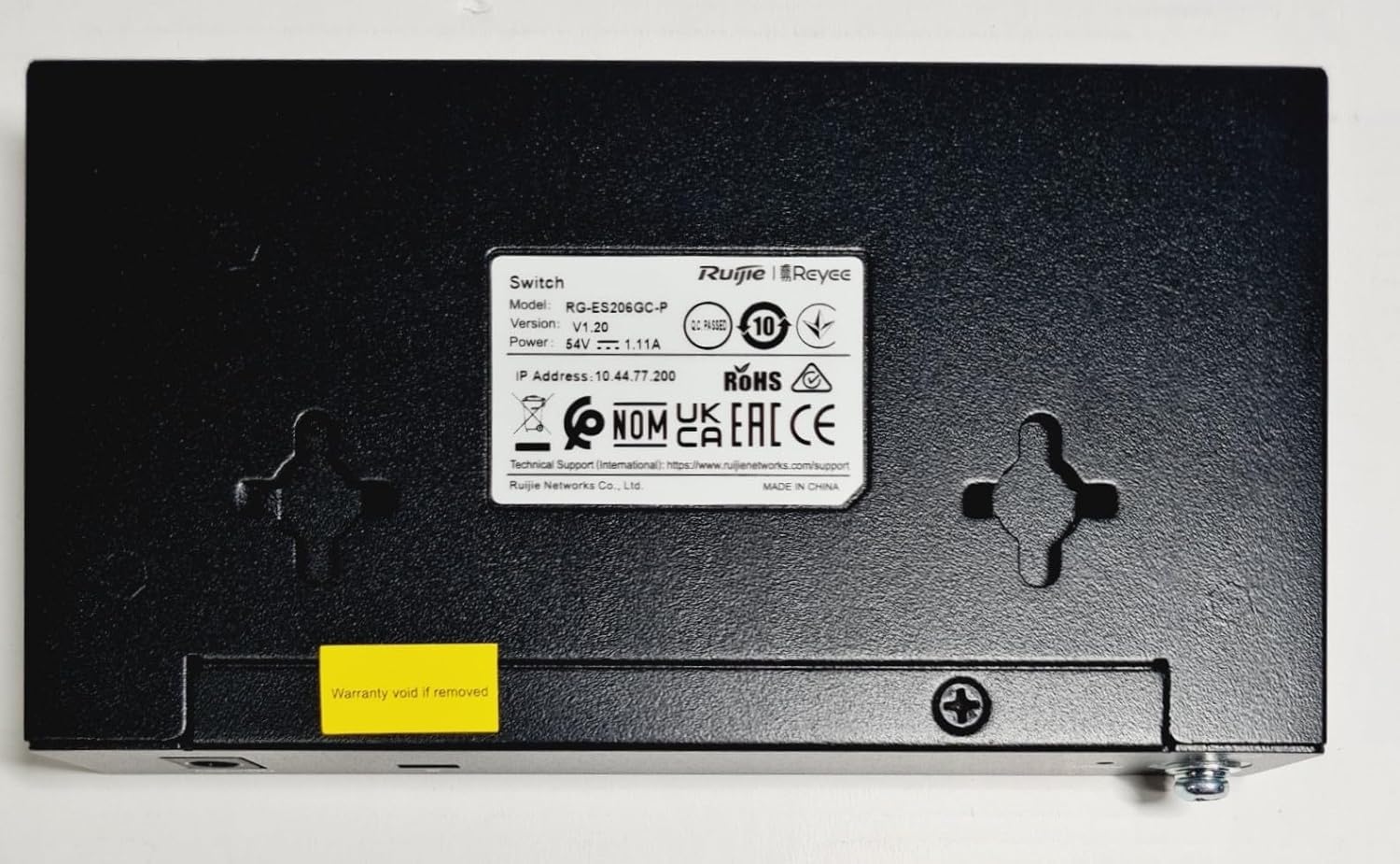 Bund view af Reyee 6-Port Gigabit Managed PoE Switchen, der viser produktmærkatet og monteringspunkterne.