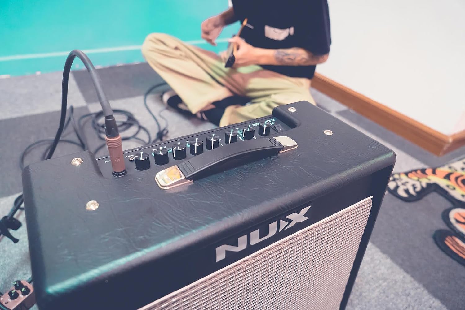 Person playing guitar with the NUX Mighty 40 BT amplifier