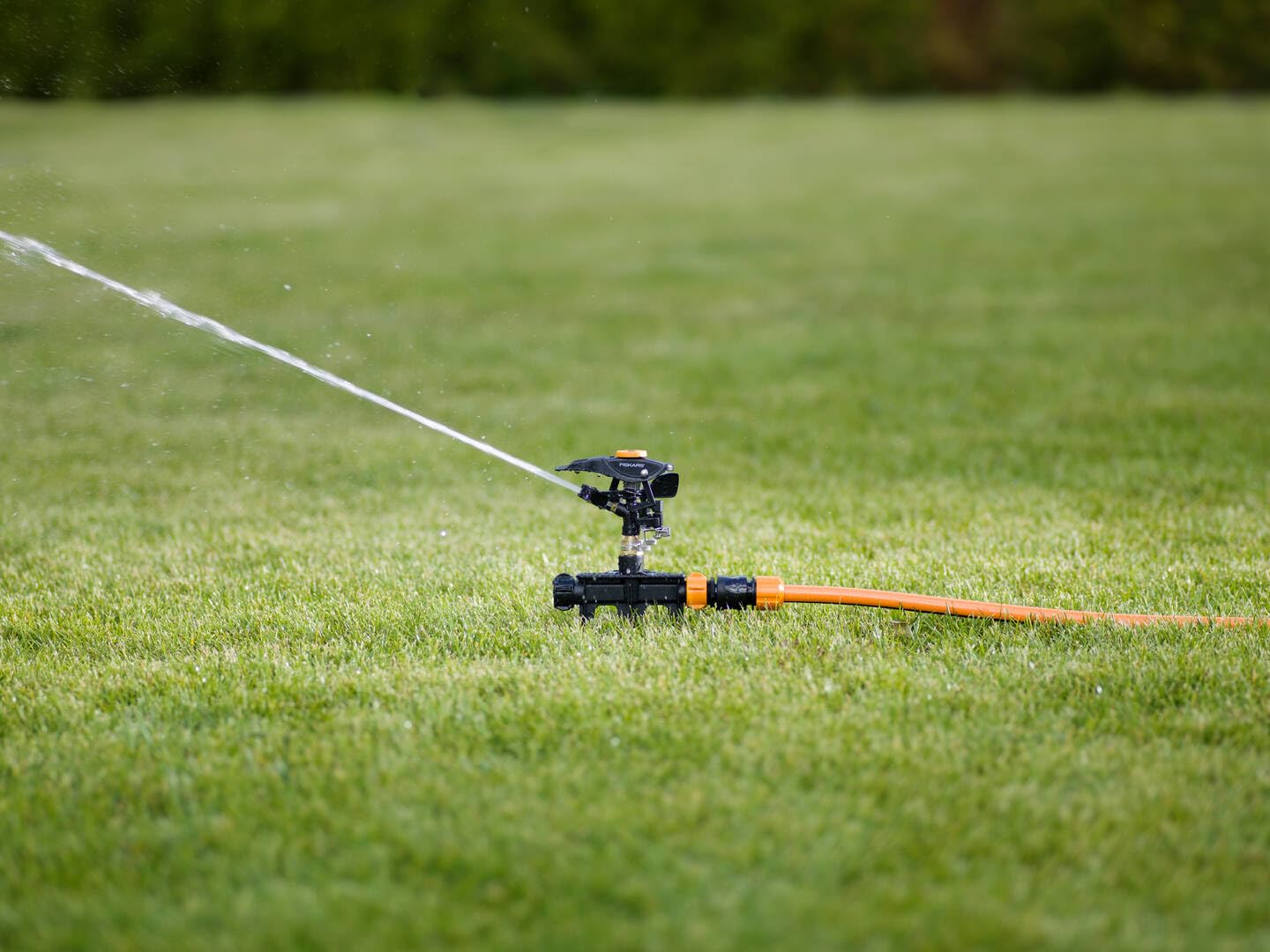 Fiskars Irrigatore a Impulso XL di Metallo con Ruote, Con Distanza | Getto e Rotazione Regolabili, Misura Universale, Portata Ø 26 m, 938 g, Nero/Arancione, 1023656