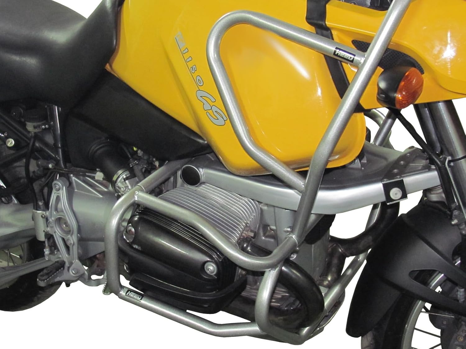 Close-up view of the silver HEED crash bars on a yellow BMW R 1150 GS, highlighting the powder-coated finish and mounting points.