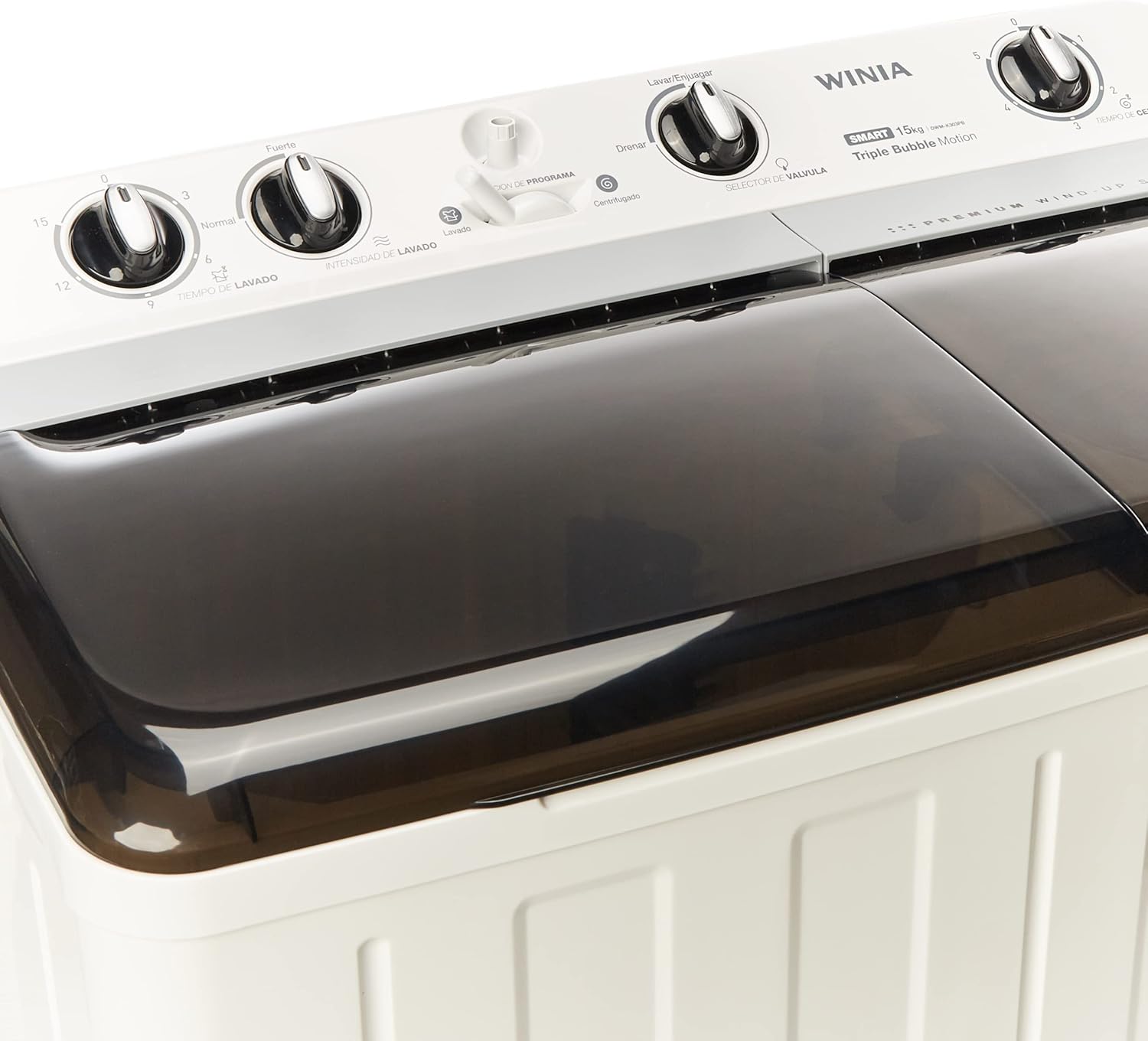 Angled top view of the WINIA DWM-K303PB washing machine with lids closed, displaying the control panel with various knobs.