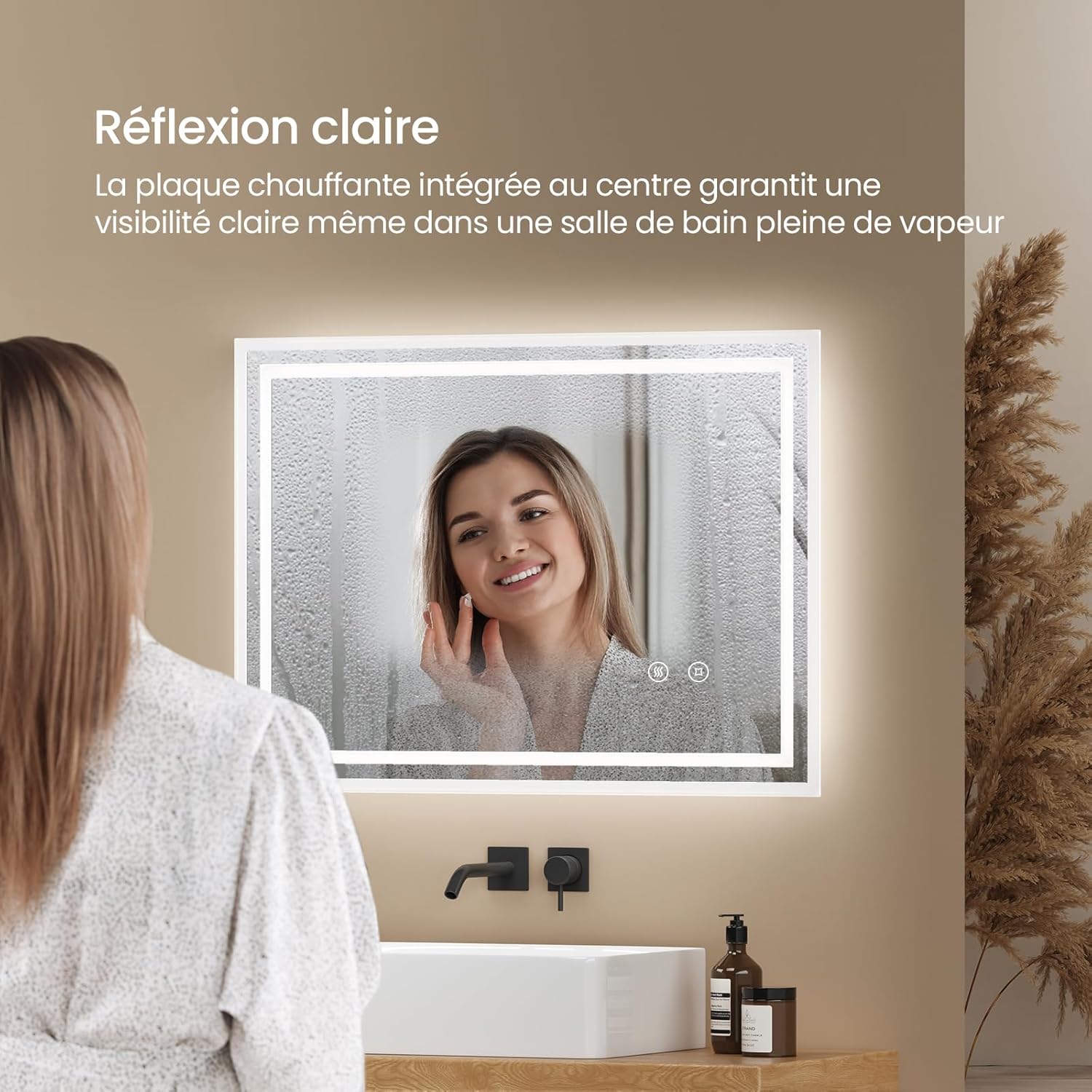 Image showing a woman looking into a clear mirror with the anti-fog function active, despite a steamy bathroom environment.