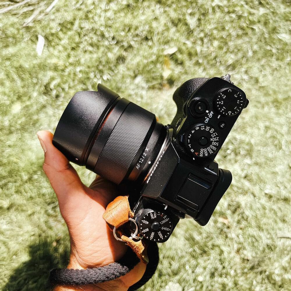 Samyang 12mm F2.0 AF lens with its petal-shaped lens hood attached, mounted on a Fujifilm X-Mount camera.