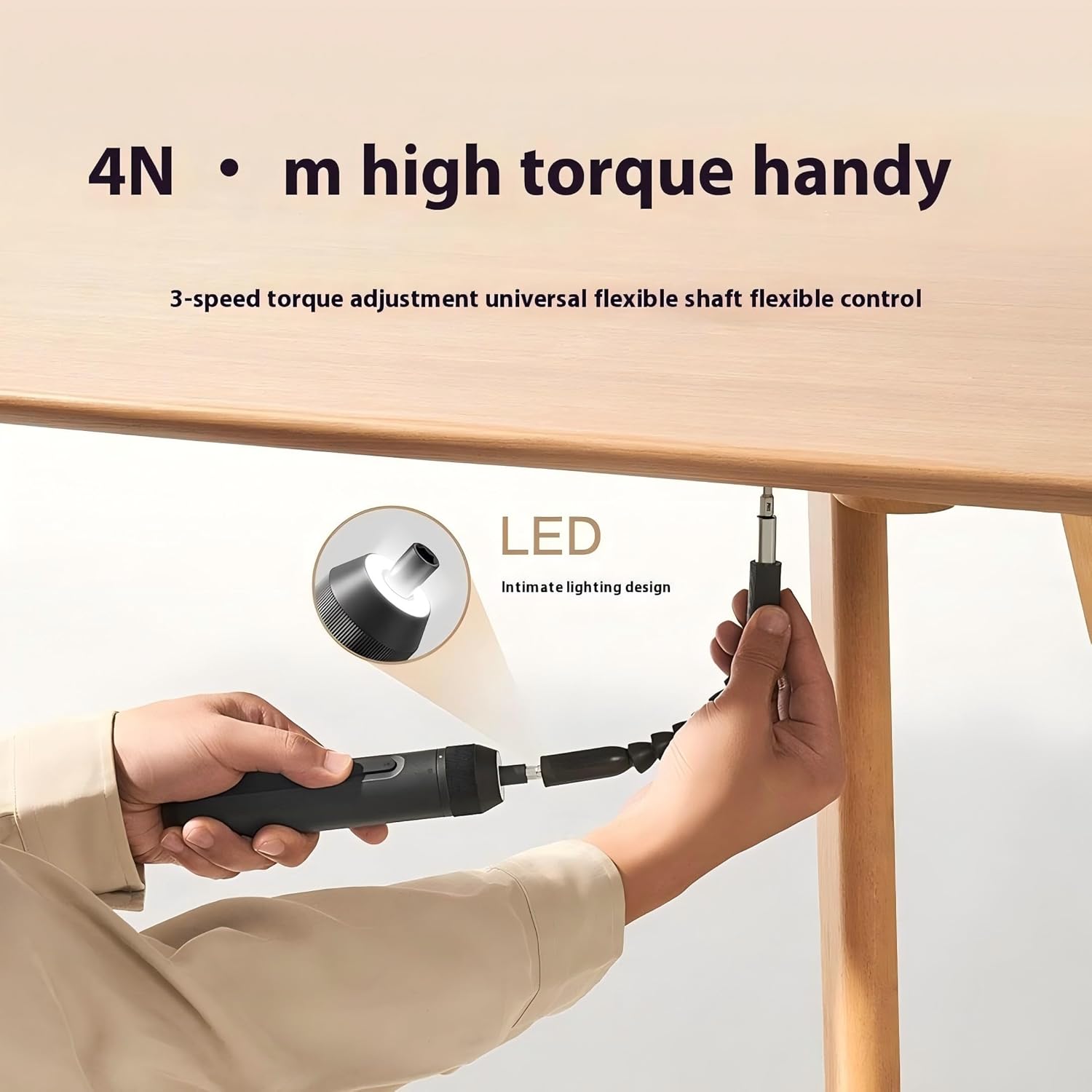 Person using the electric screwdriver with an extension rod to fasten a screw under a table.