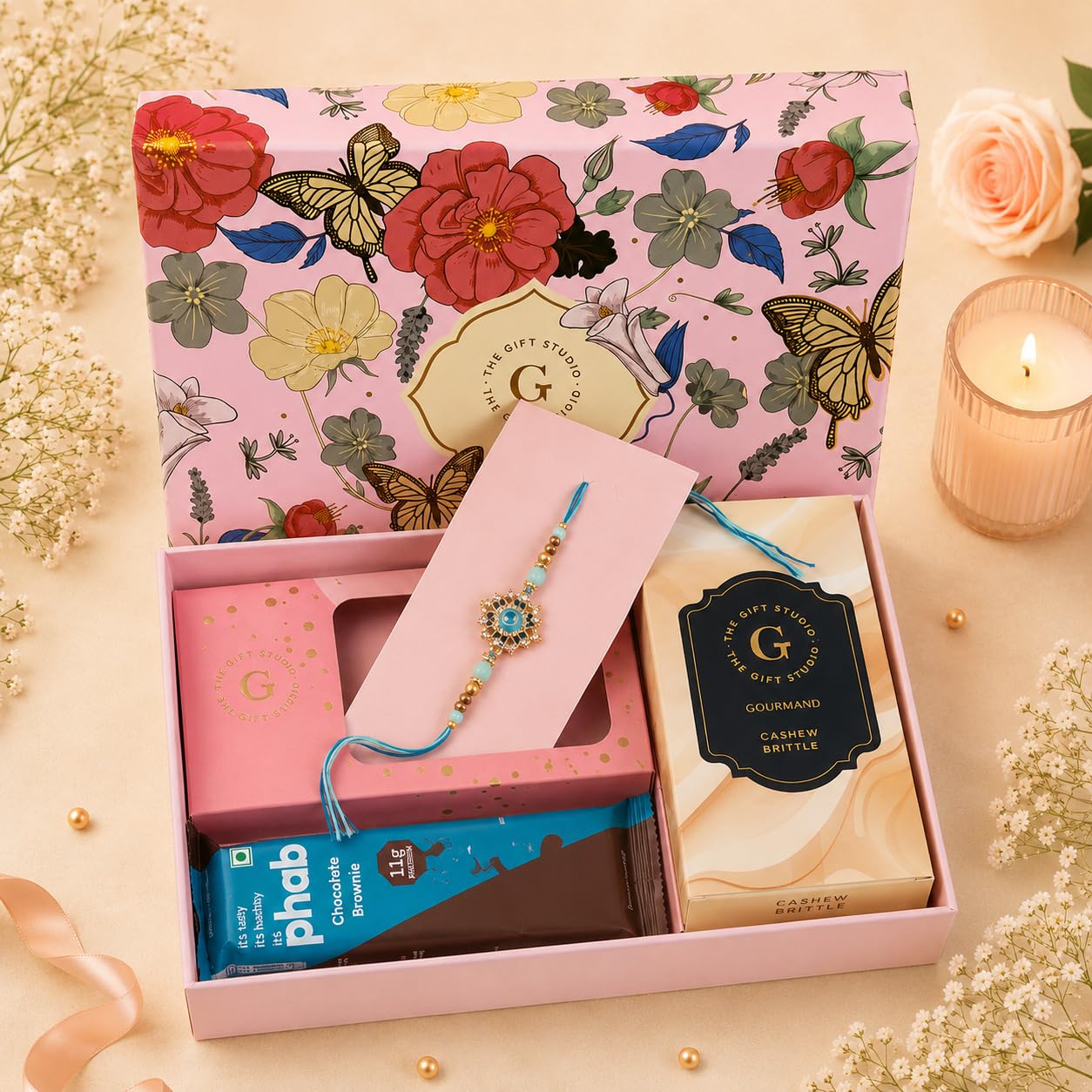 the gift studio.com | classic rakhi gift hamper for brother | designer meenakari rakhi, cashew brittle, protein brownie & celebration box | raksha bandhan gift