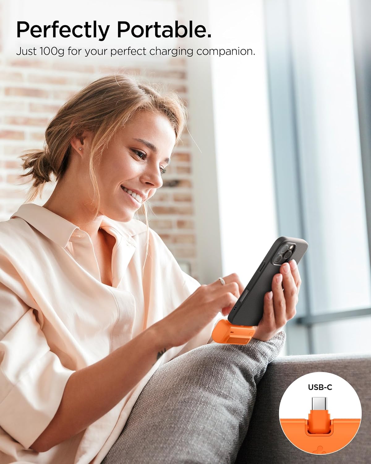 User holding a phone being charged by the portable Spigen ArcPack power bank.