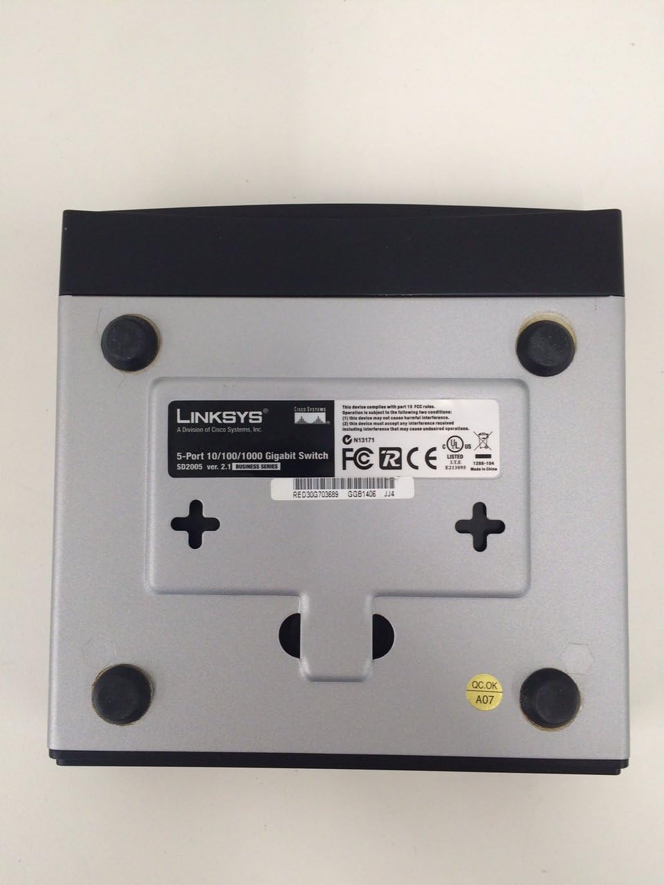 Bottom view of the Linksys SD2005 5-Port Gigabit Ethernet Switch, showing regulatory labels and mounting points.