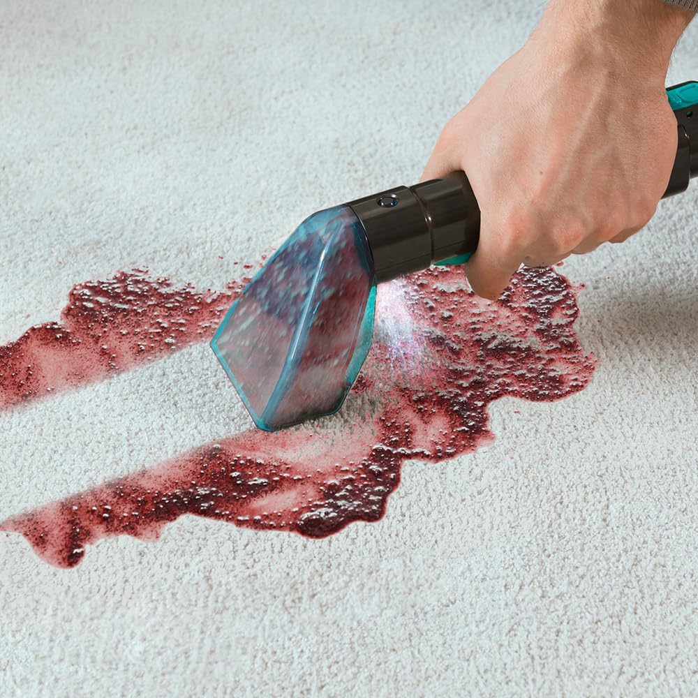 Spot cleaner removing a red stain from a carpet
