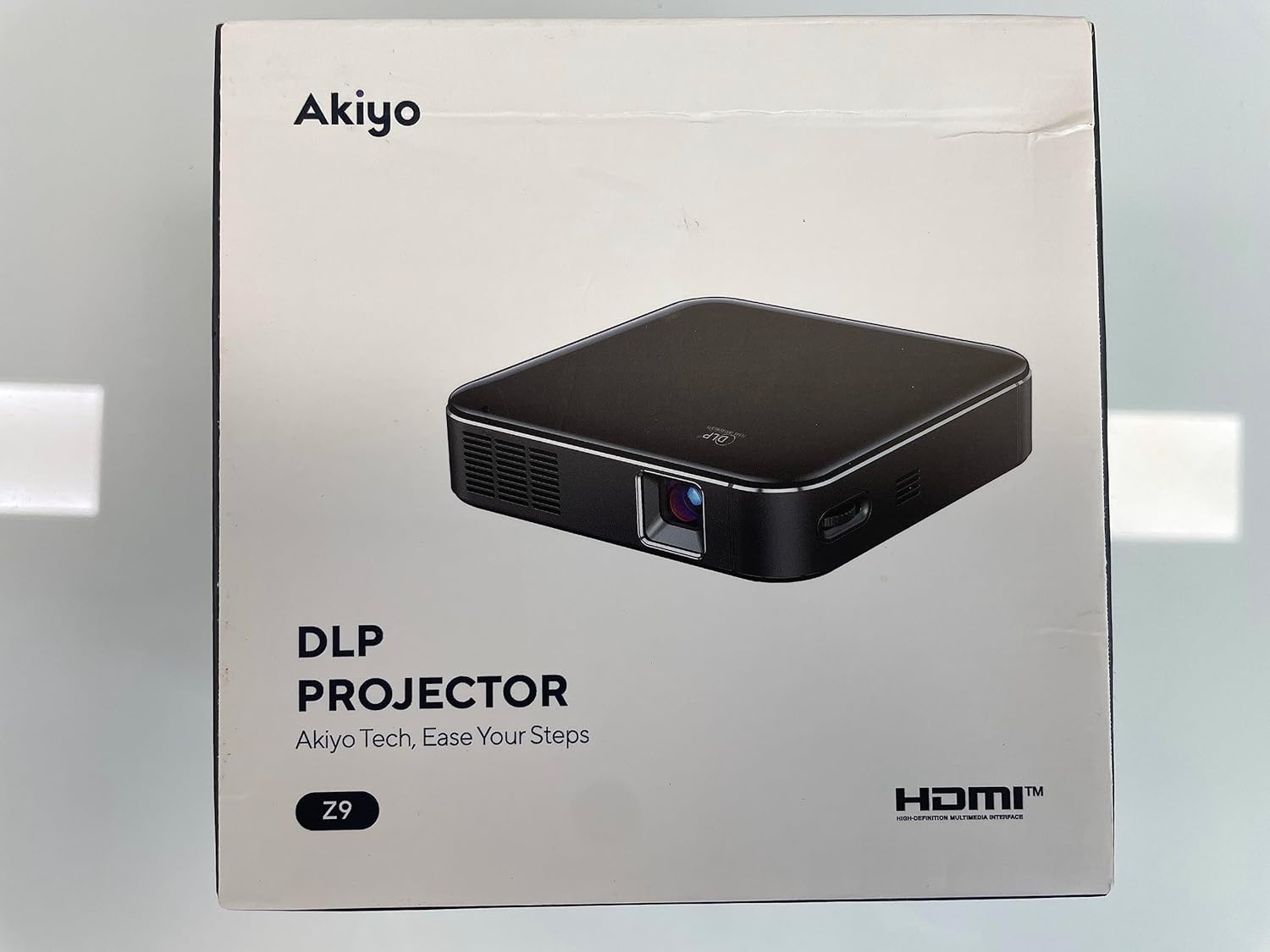 Diagram of the AKIYO Z9 Mini DLP Projector showing its various ports and controls. Labels include USB-C charging, HDMI, USB out, Audio out, Keystone, Volume, Focus, Brightness, and Power Supply.