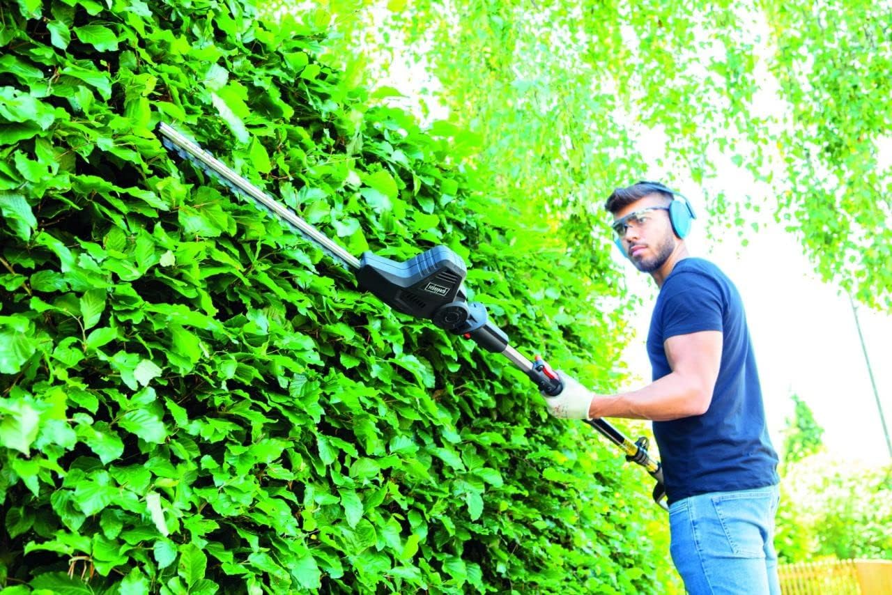 User operating Scheppach TPX710 hedge trimmer on a hedge