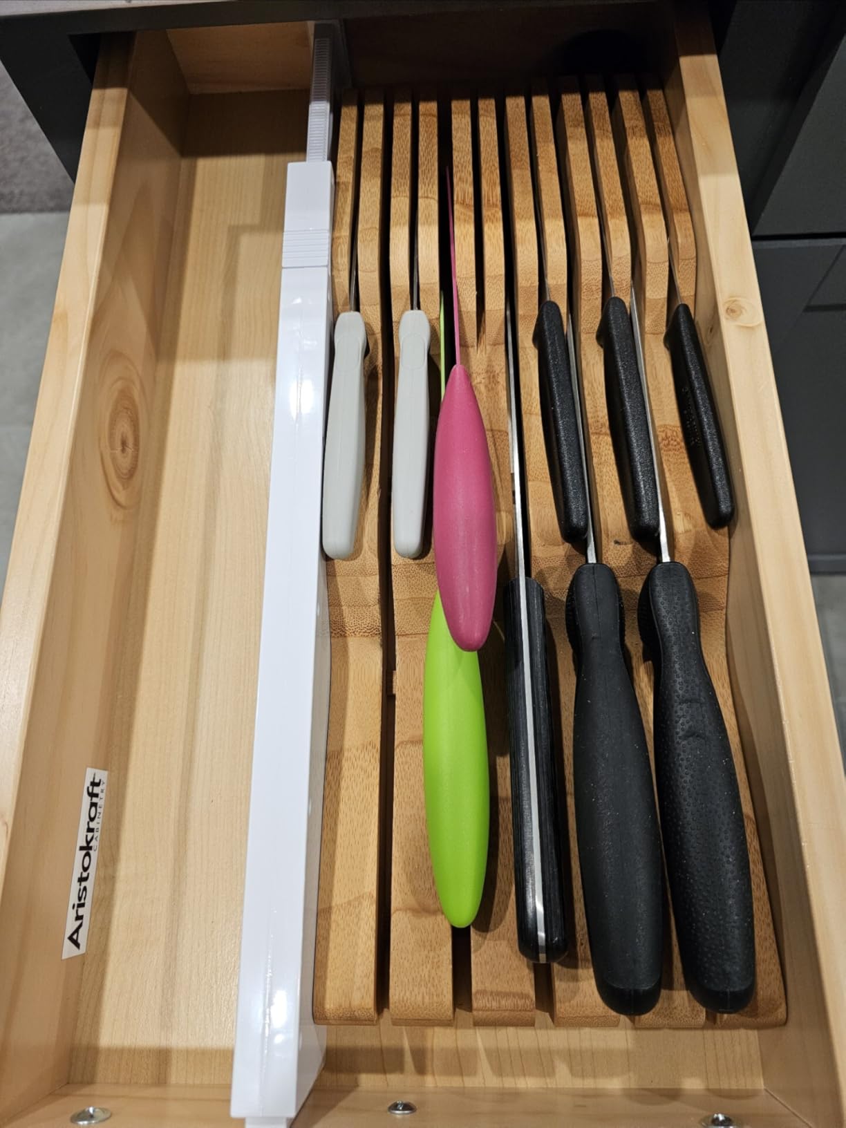 Adjustable drawer dividers separating kitchen drawer contents