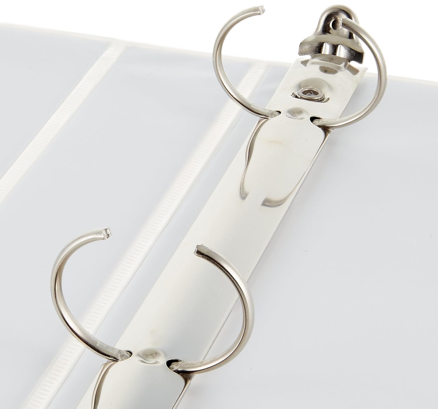 A close-up view of the metal rings inside a white 3-ring binder, showing them slightly open.