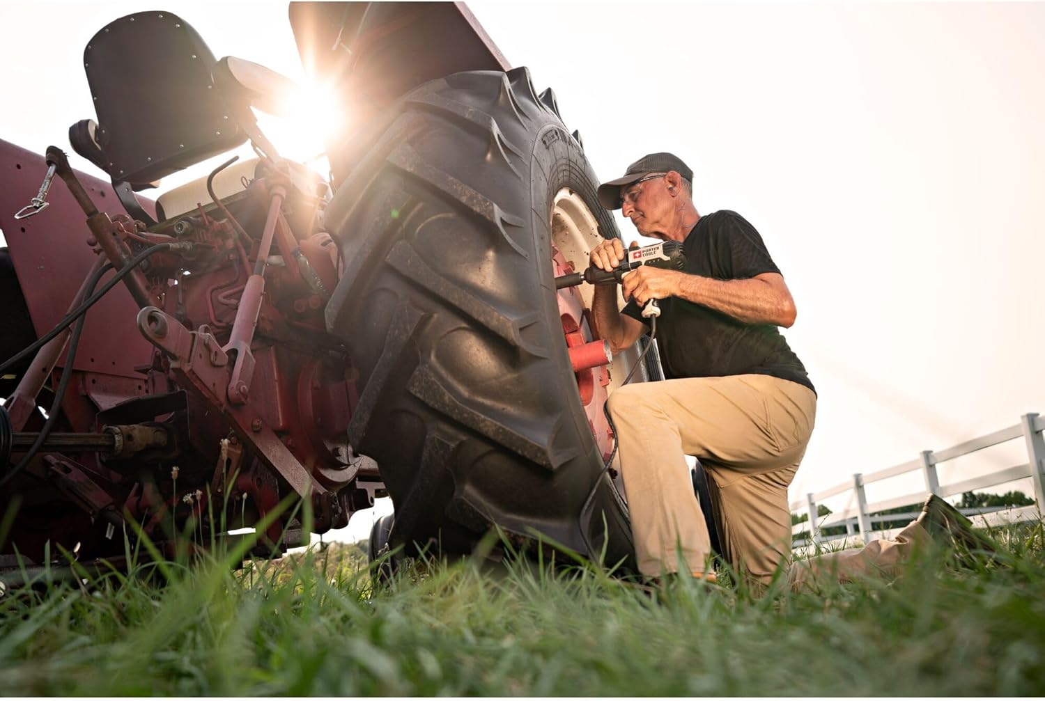 Person using PORTER-CABLE impact wrench on a tractor wheel