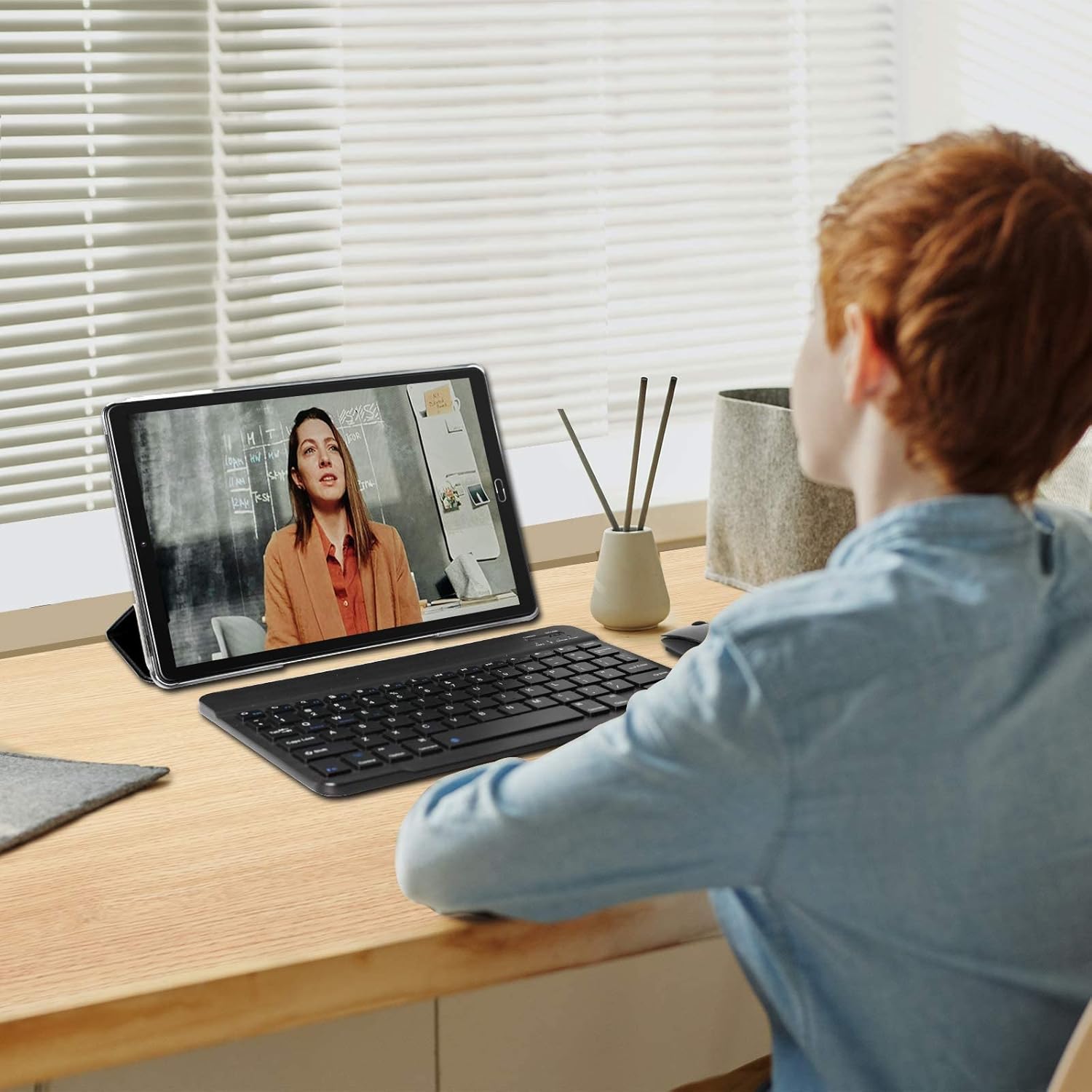 GOODTEL G10 tablet connected to an external keyboard, used by a student for online learning or productivity tasks.
