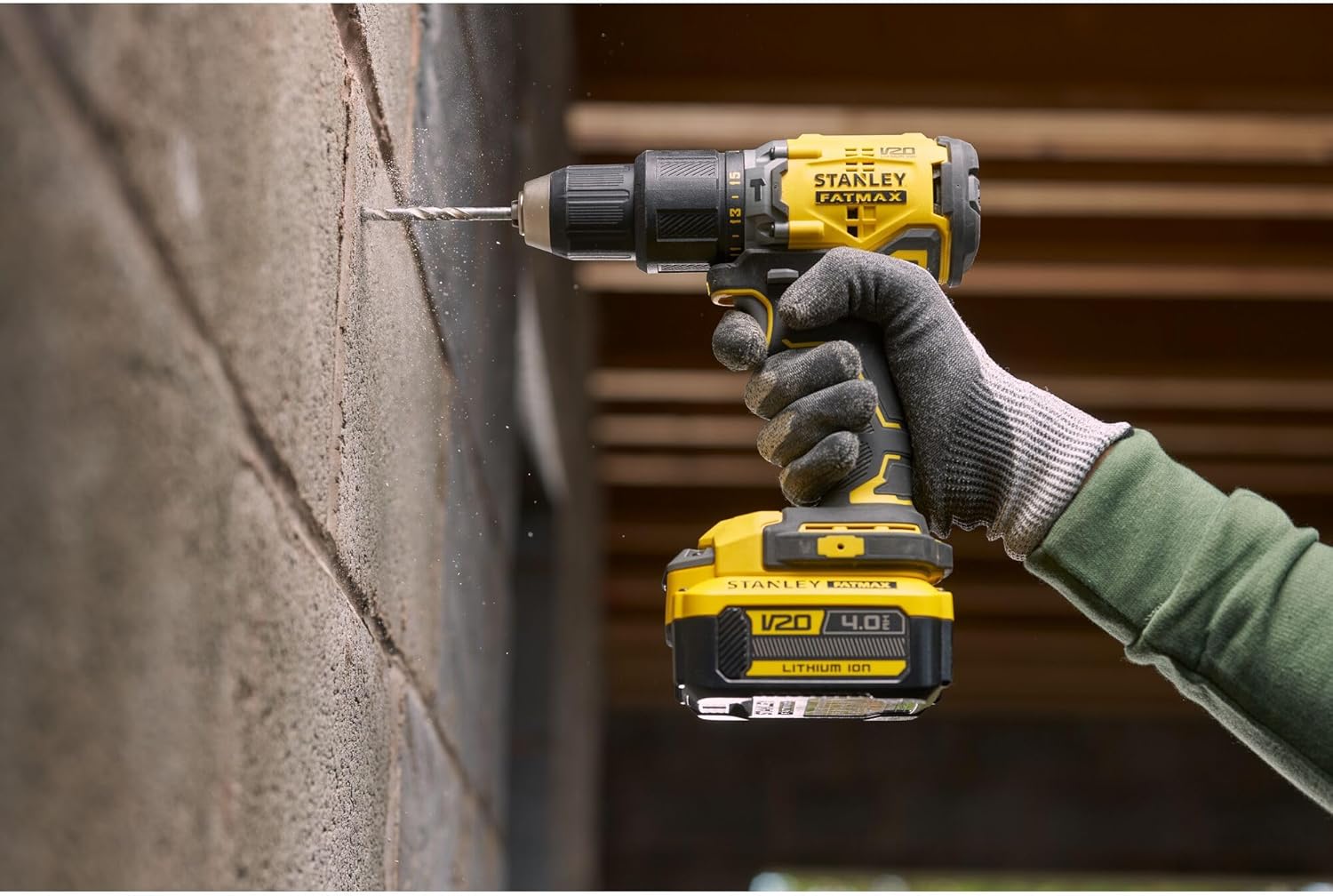 A person using a drill powered by a Stanley FATMAX V20 4Ah Lithium Ion Battery to drill into a wall.