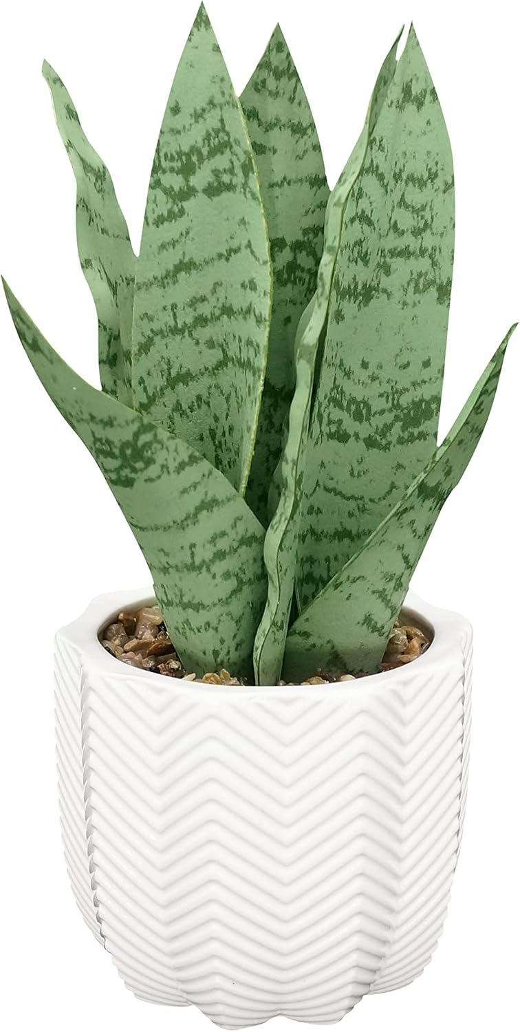 Hisow faux snake plant in a small white ceramic pot on the corner of a desk