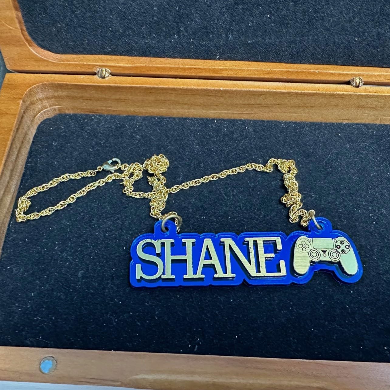 Sports Fan Player Gamer Themed Nameplate Necklace with Gold Laser Cut Letters and Game Controller on Blue Mirror Background with Gold Chain Personalized Made to Order Custom Any Name Great Gift Idea Made in CT, USA