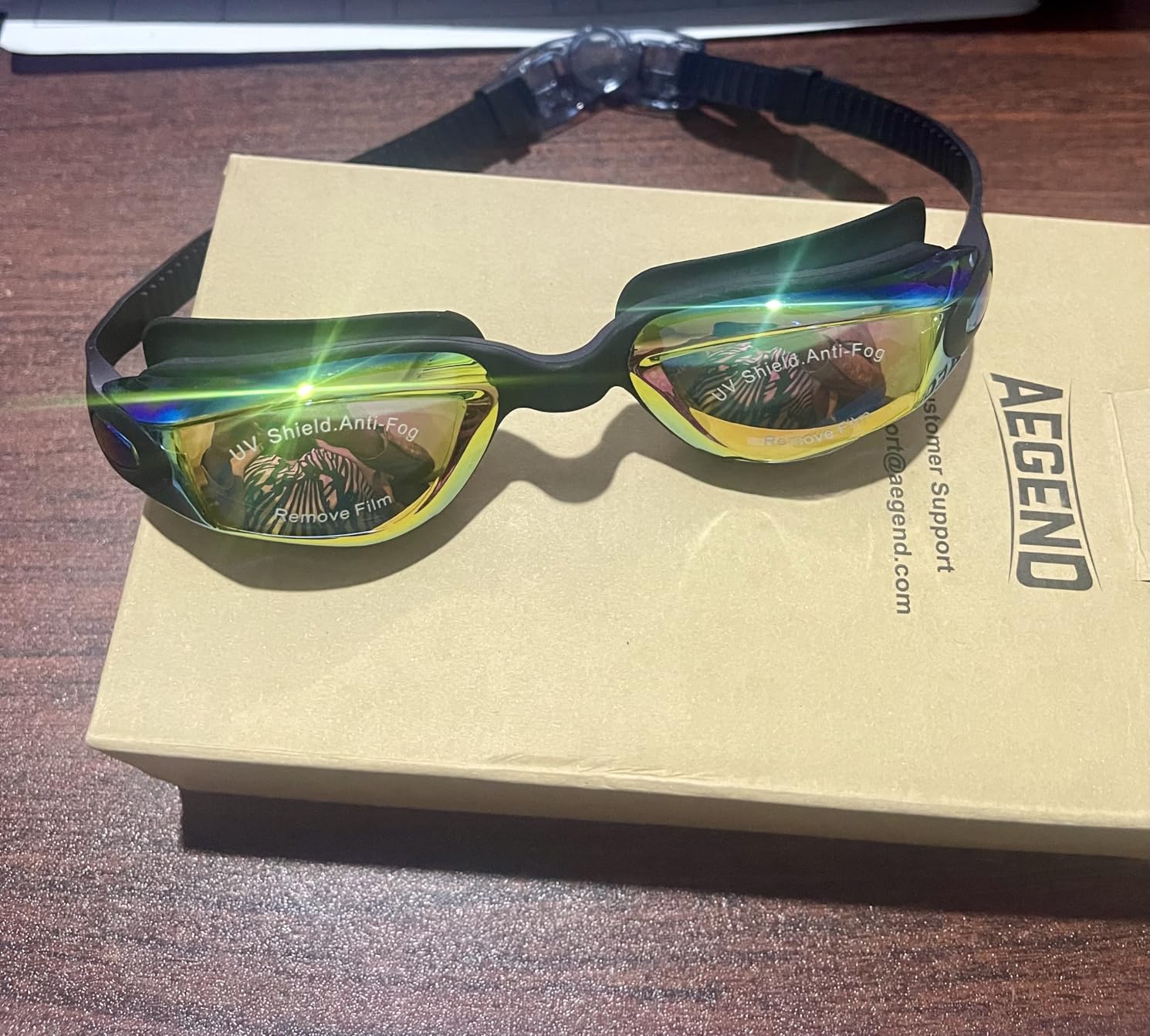 Kids swim goggles laid flat showing anti-fog lenses and adjustable strap