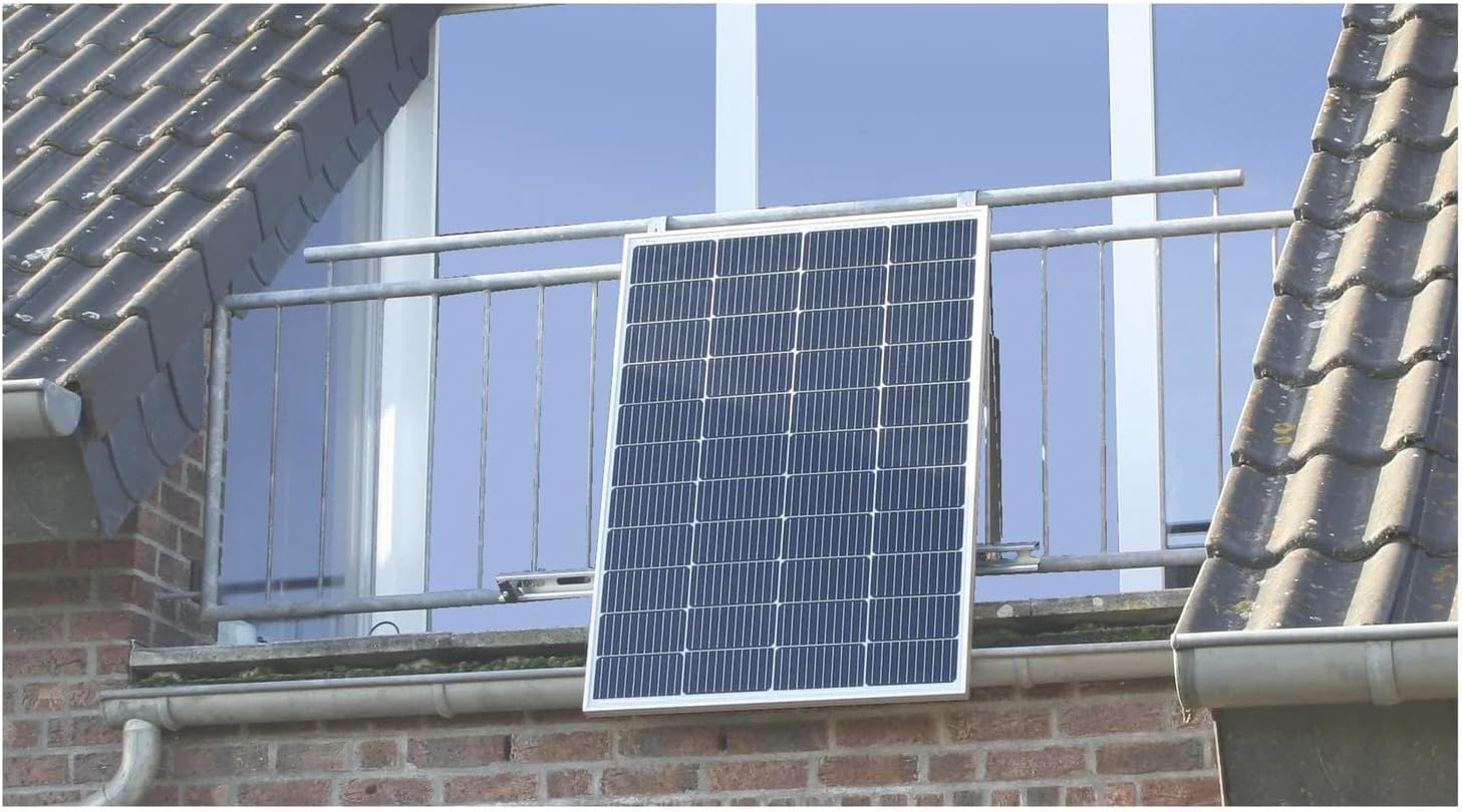 Solar panel mounted vertically on a balcony railing of a brick building.