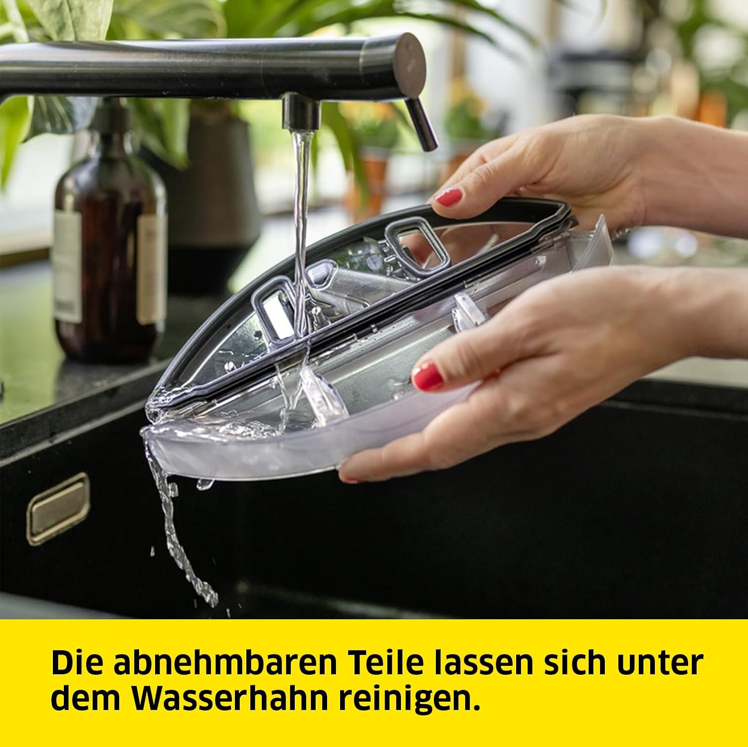 Hands cleaning a removable part of the Kärcher RCF 3 under running water