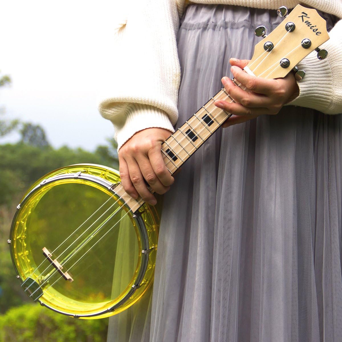 Person holding Kmise Banjo Ukulele, demonstrating playing position
