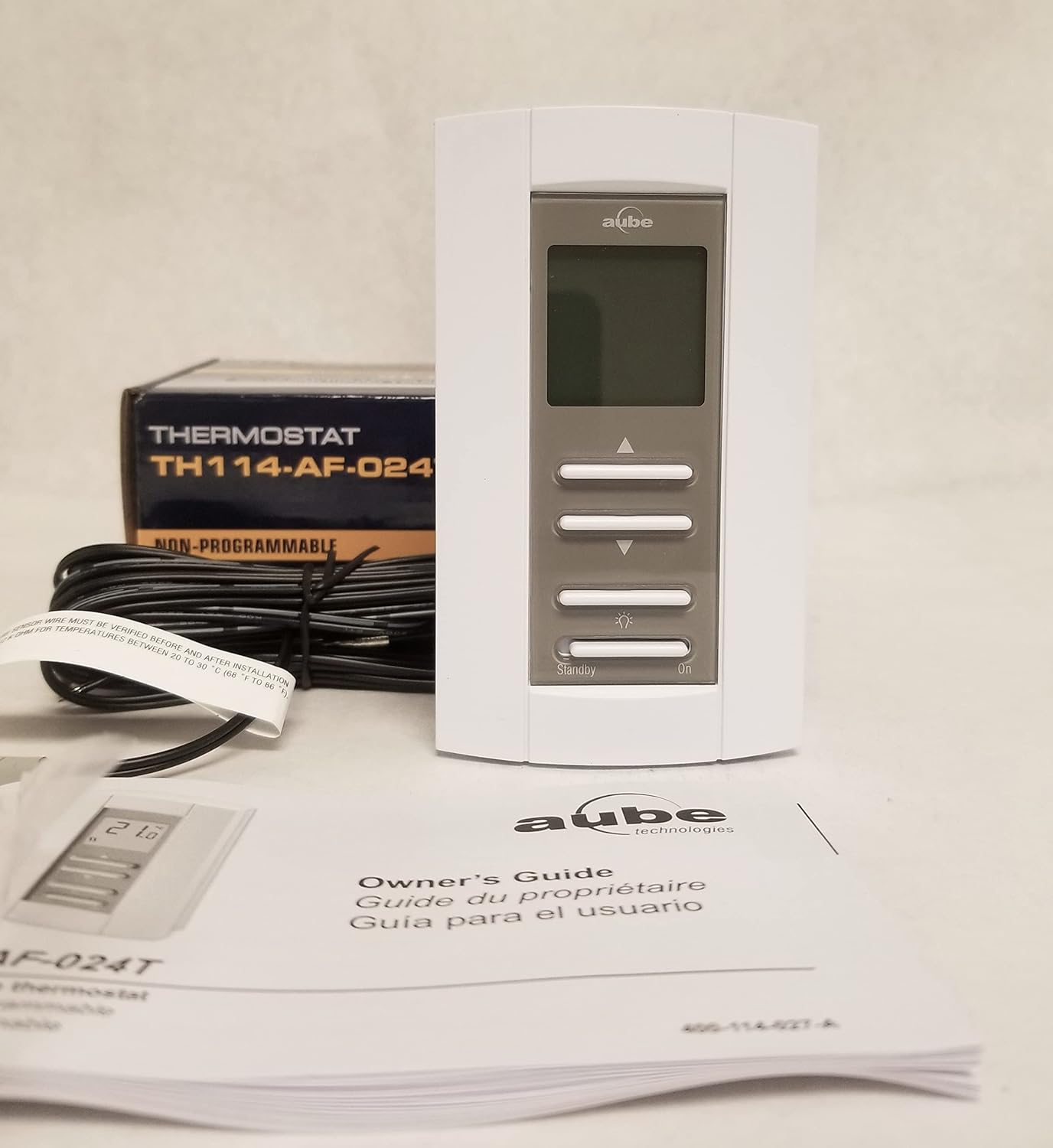 Aube TH114-AF-024T non-programmable floor heat thermostat with its packaging and owner's guide.