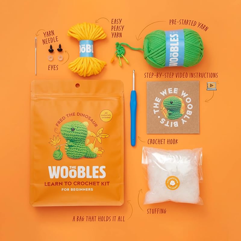 The Woobles Fred the Dinosaur Beginner Plus crochet kit with green yarn, hook, eyes, stuffing and finished dinosaur example
