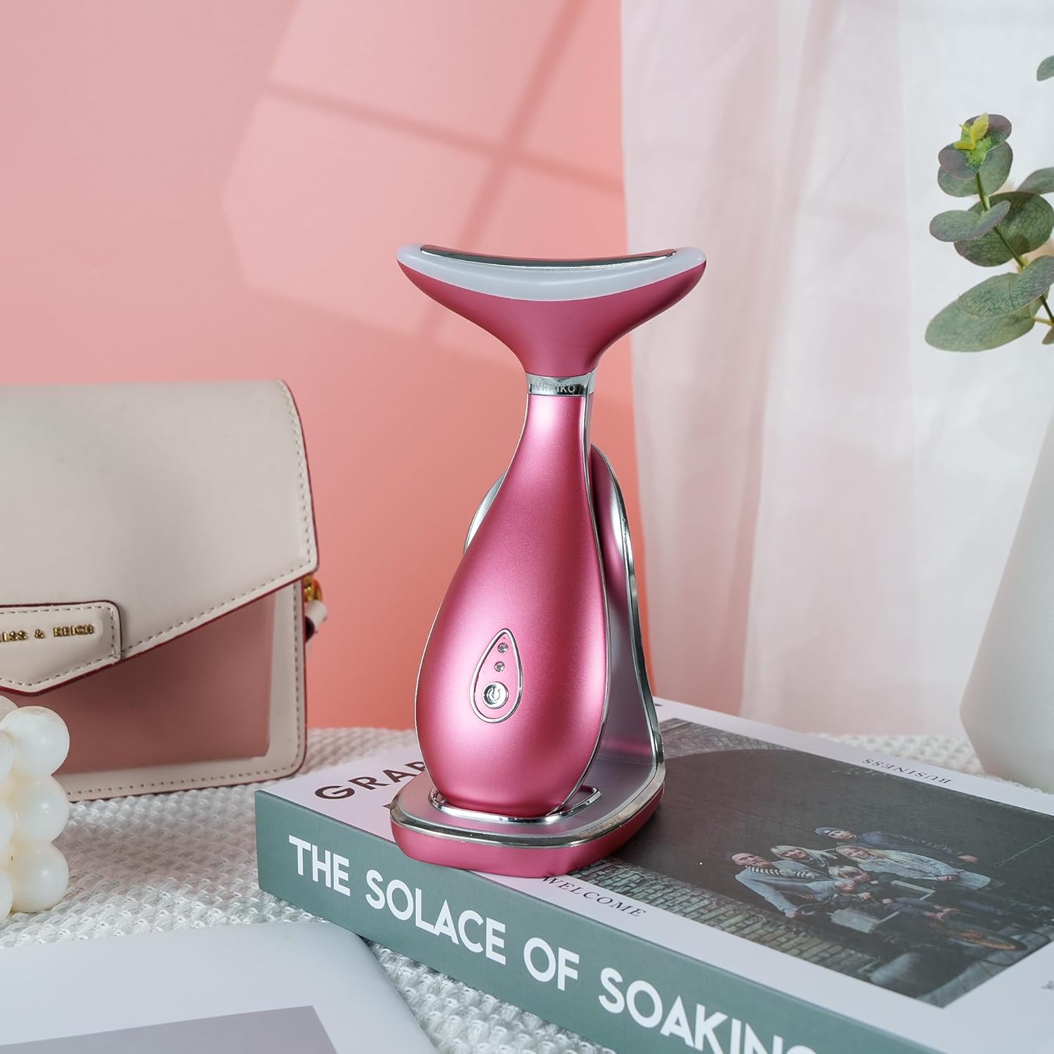 VRAIKO Lily Neck Face Massager on its charging stand