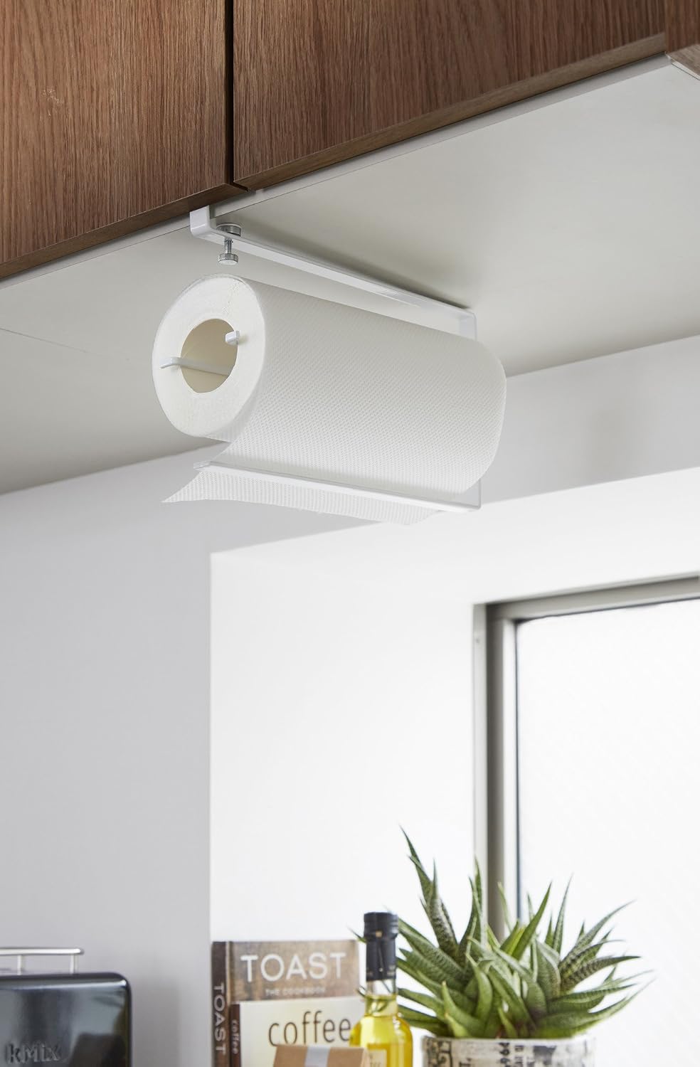 Yamazaki kitchen paper holder installed under a cabinet with a paper roll loaded.