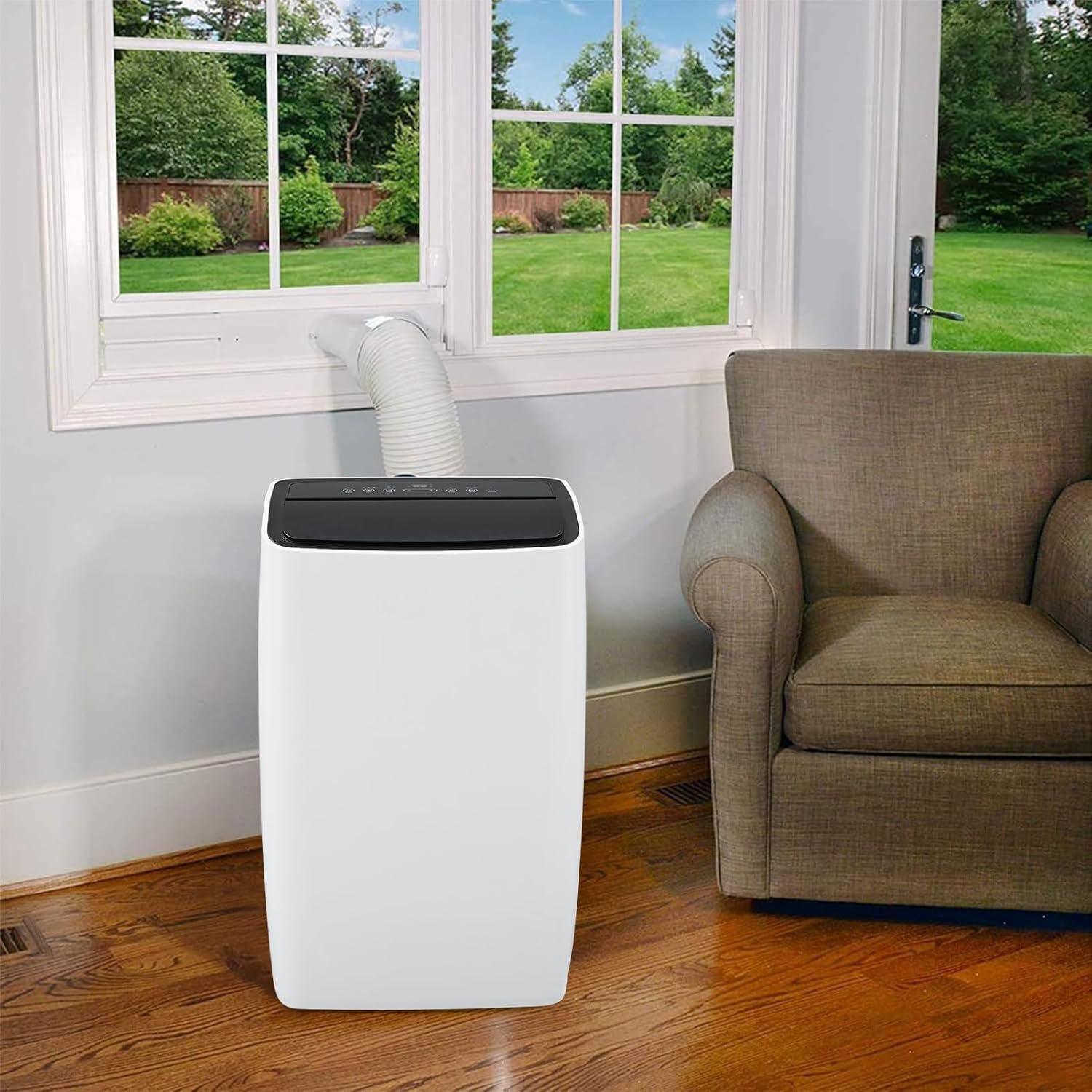 Garvee portable air conditioner installed in a living room next to a window with the exhaust hose connected.