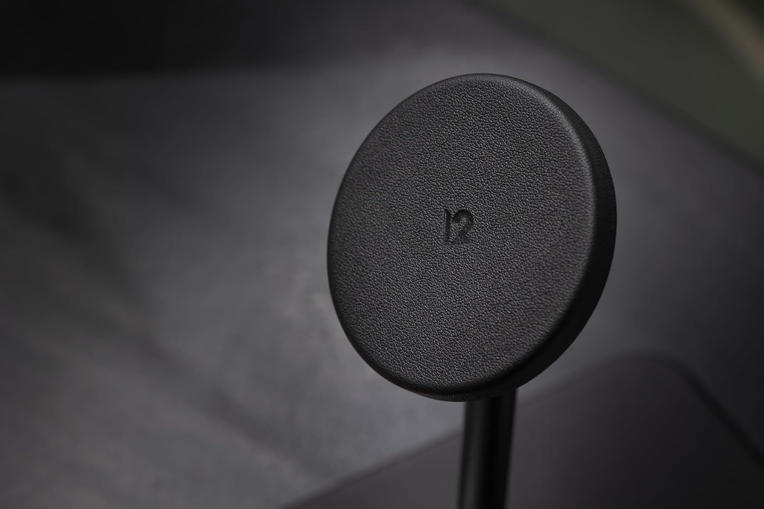 Close-up of an Apple Watch charging on the Twelve South HiRise 3 Deluxe, displaying a green charging icon on its screen.