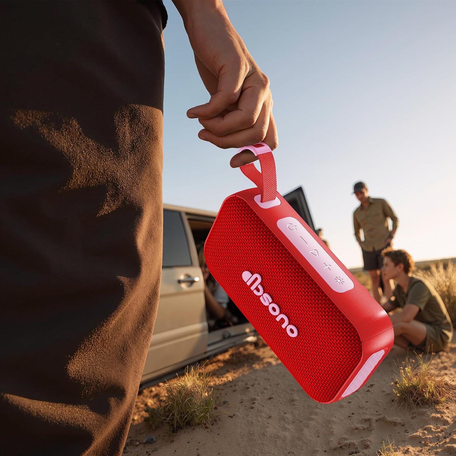 A hand holding the dbsono Portable Bluetooth Speaker outdoors, demonstrating its portability.