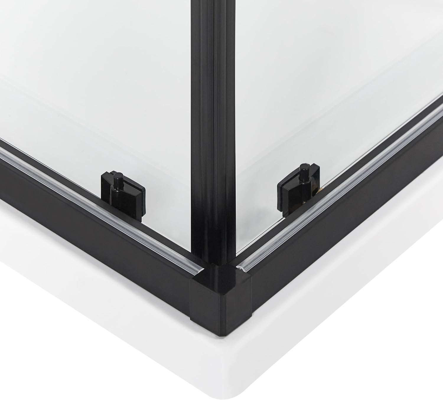 Close-up of the bottom corner joint of the black aluminum frame and glass panel of the shower cabin.
