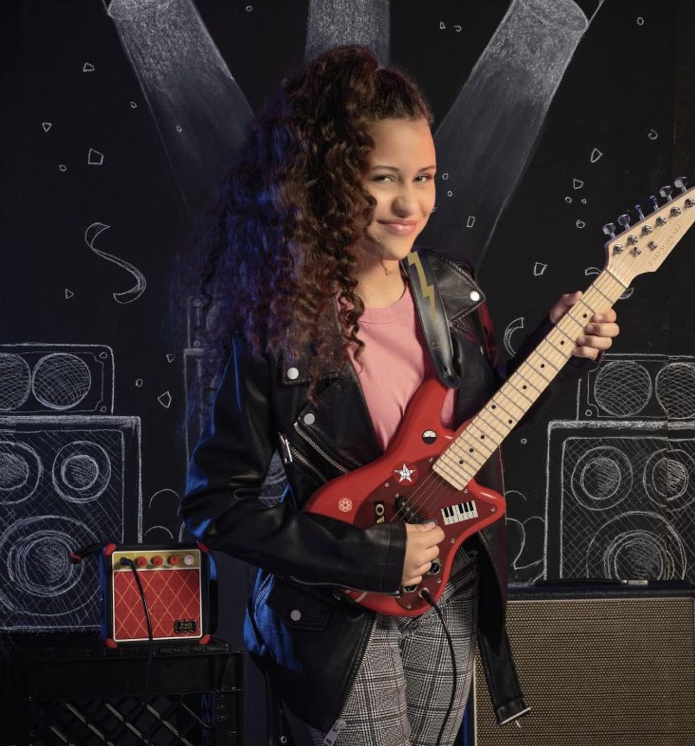 Child playing the FAO Schwarz electric guitar with the amplifier in the background