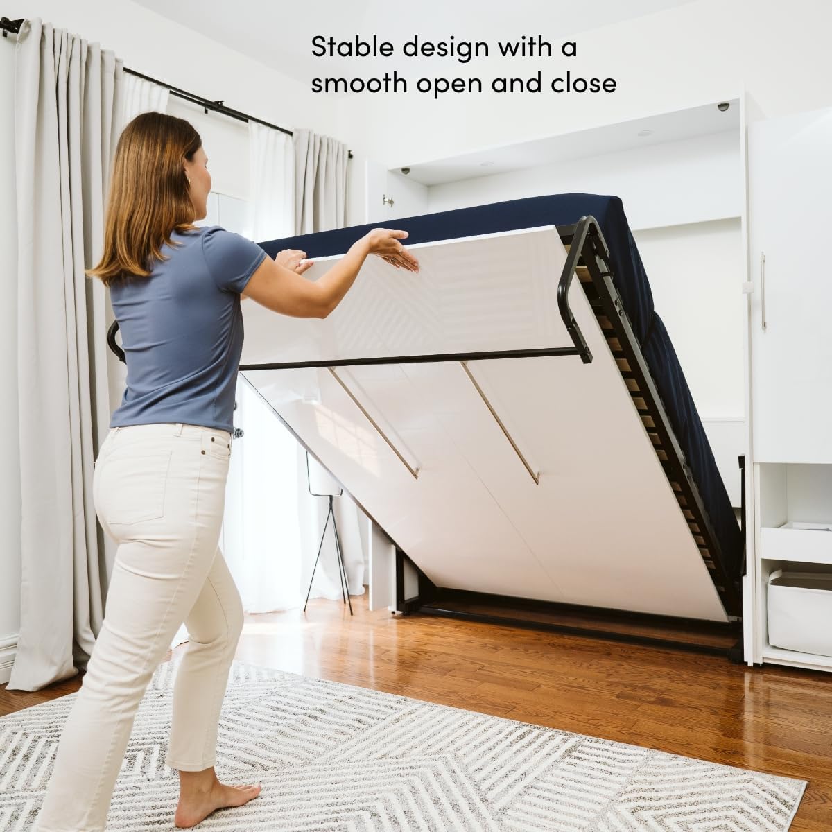 A person demonstrating the smooth opening and closing of the Murphy bed, highlighting its stable design.