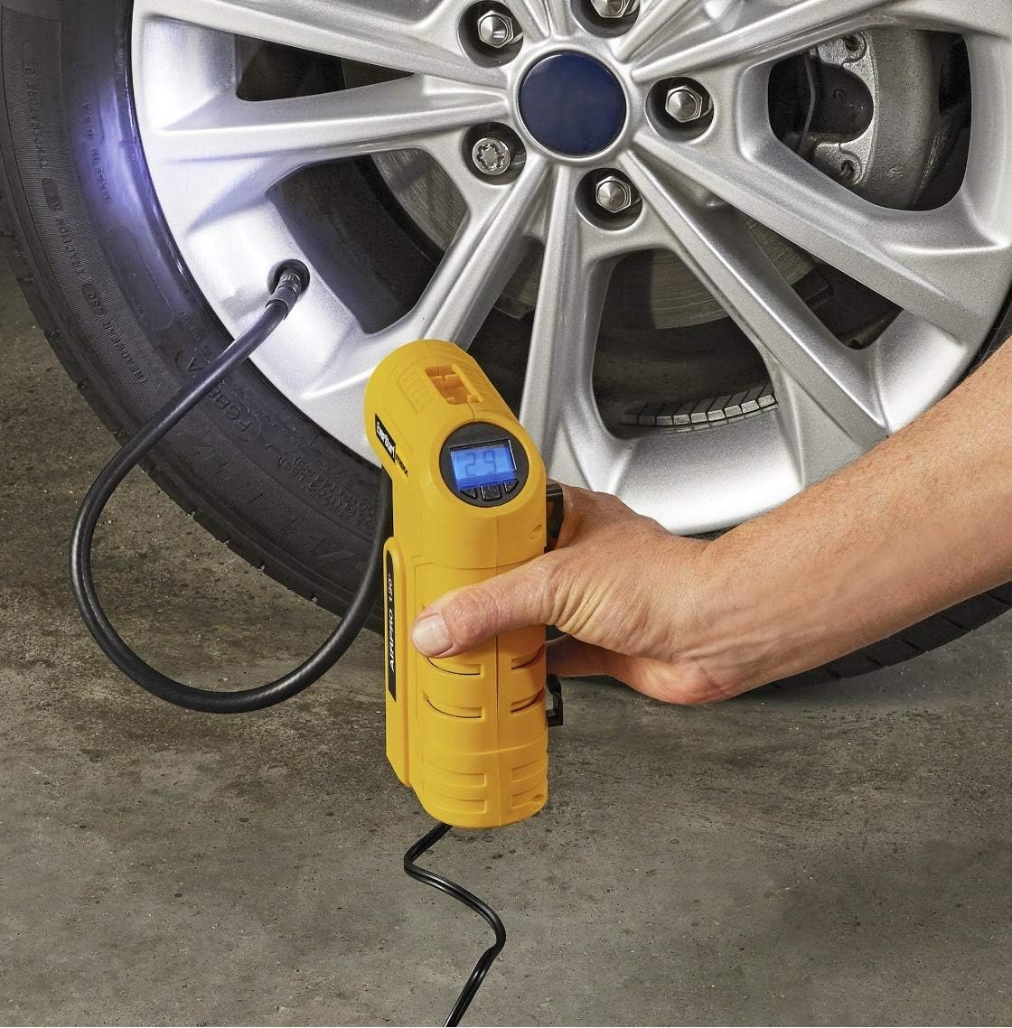 Person inflating a car tire with the EverStart MAXX compressor