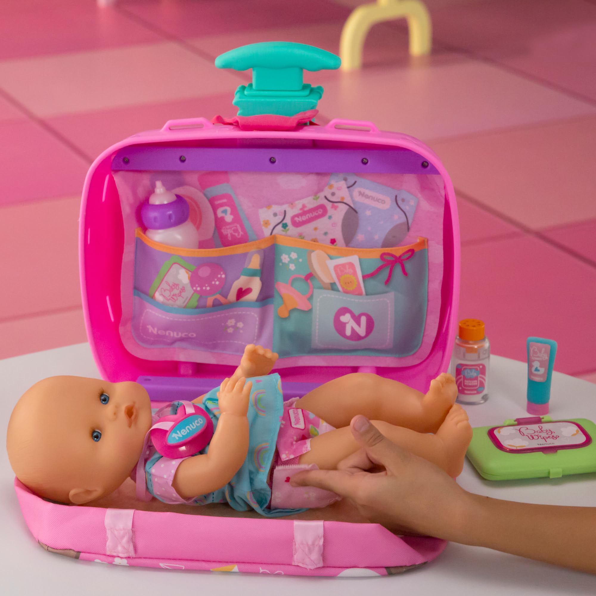 Nenuco - Viaja Conmigo, Muñeco de 30 cm con Cuerpo Duro con Maleta Cambiador, Incluye Cinturón para Transporte Seguro y 6 Accesorios de Cuidado, +2 años, Famosa (NFNC9000)