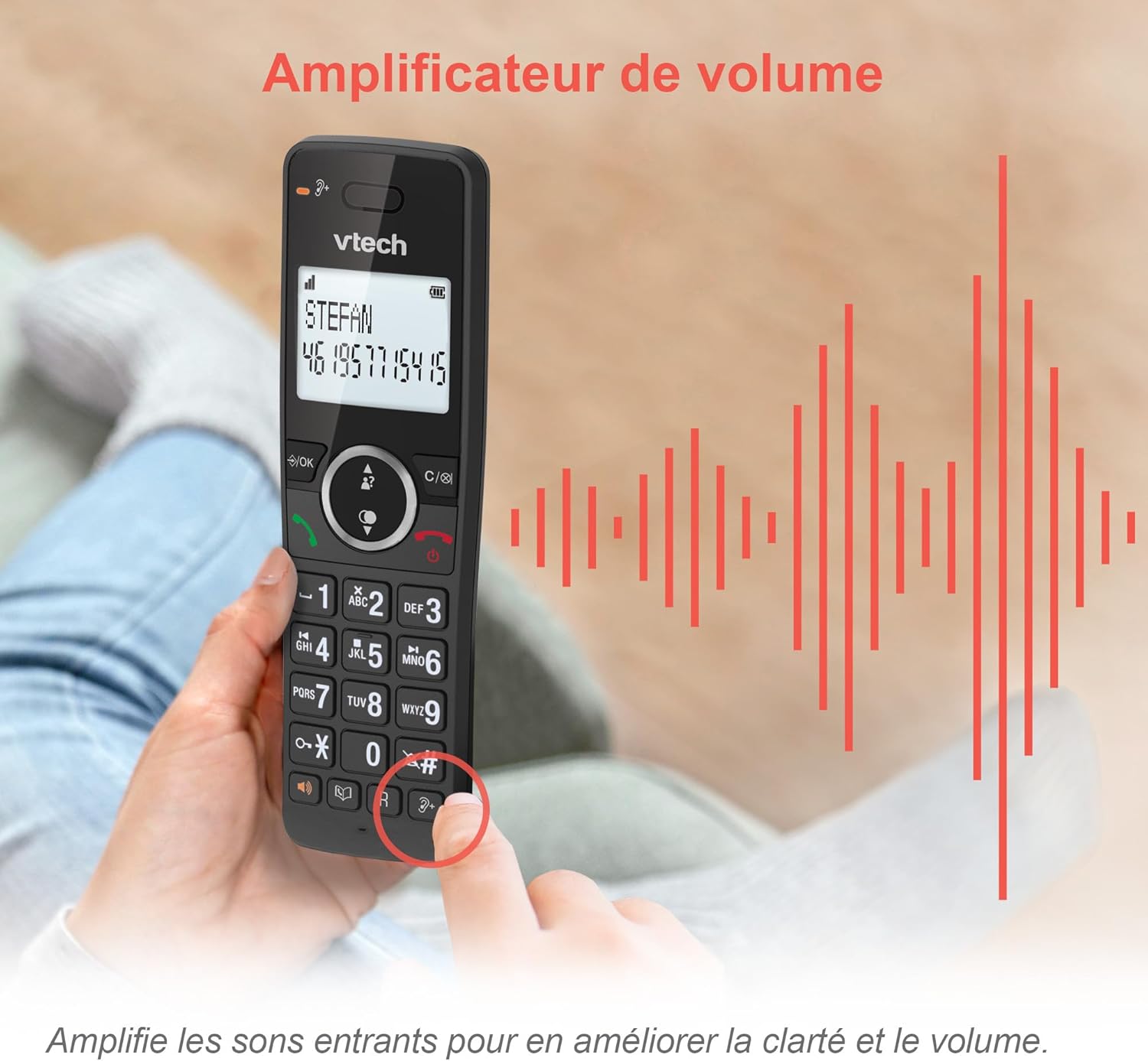 A hand holding the VTech ES2051 phone, with visual sound waves indicating the volume ampfunkcja lizacji.