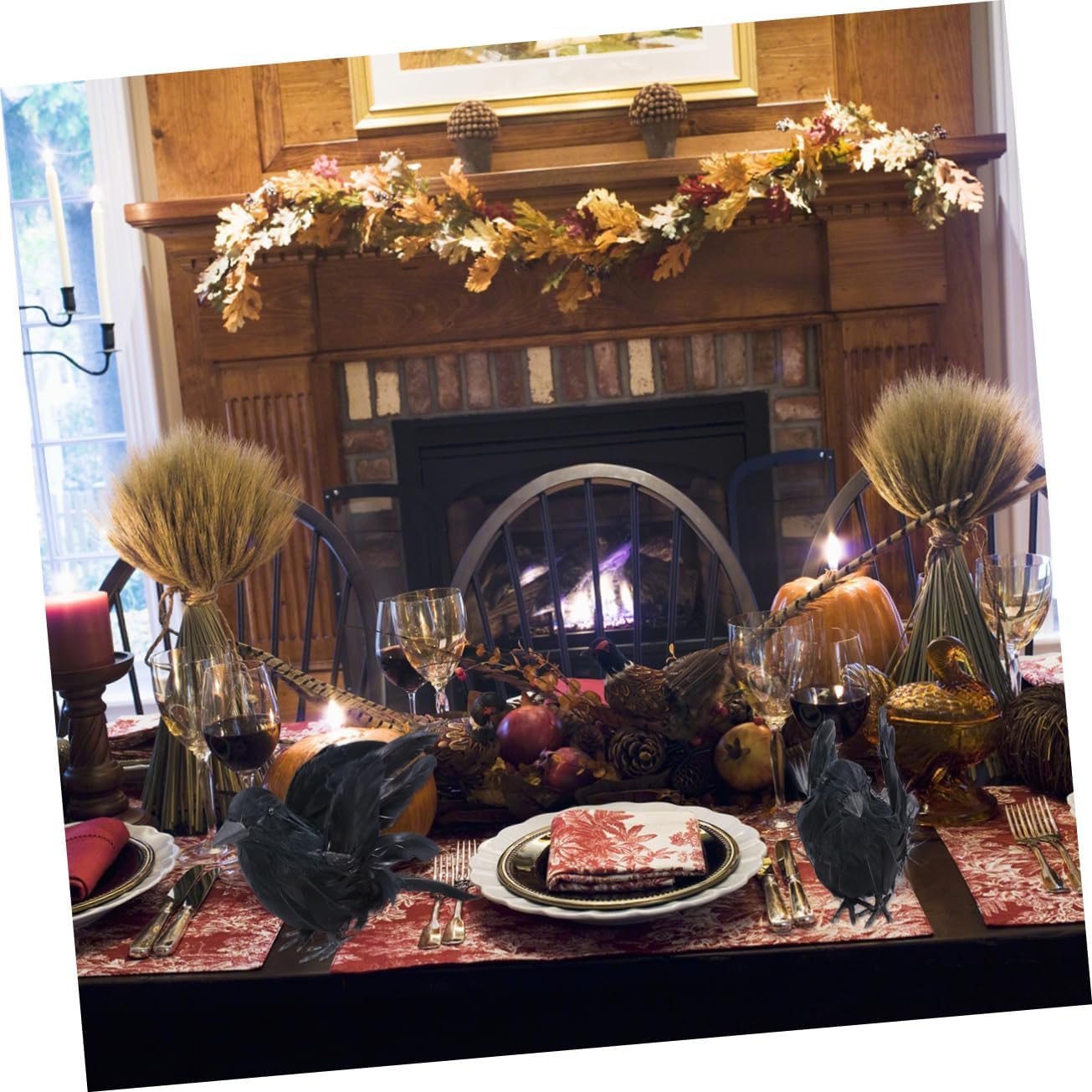 A black crow decoration placed on a table with other Halloween decorations, including a skull and autumn leaves, in a dimly lit room.