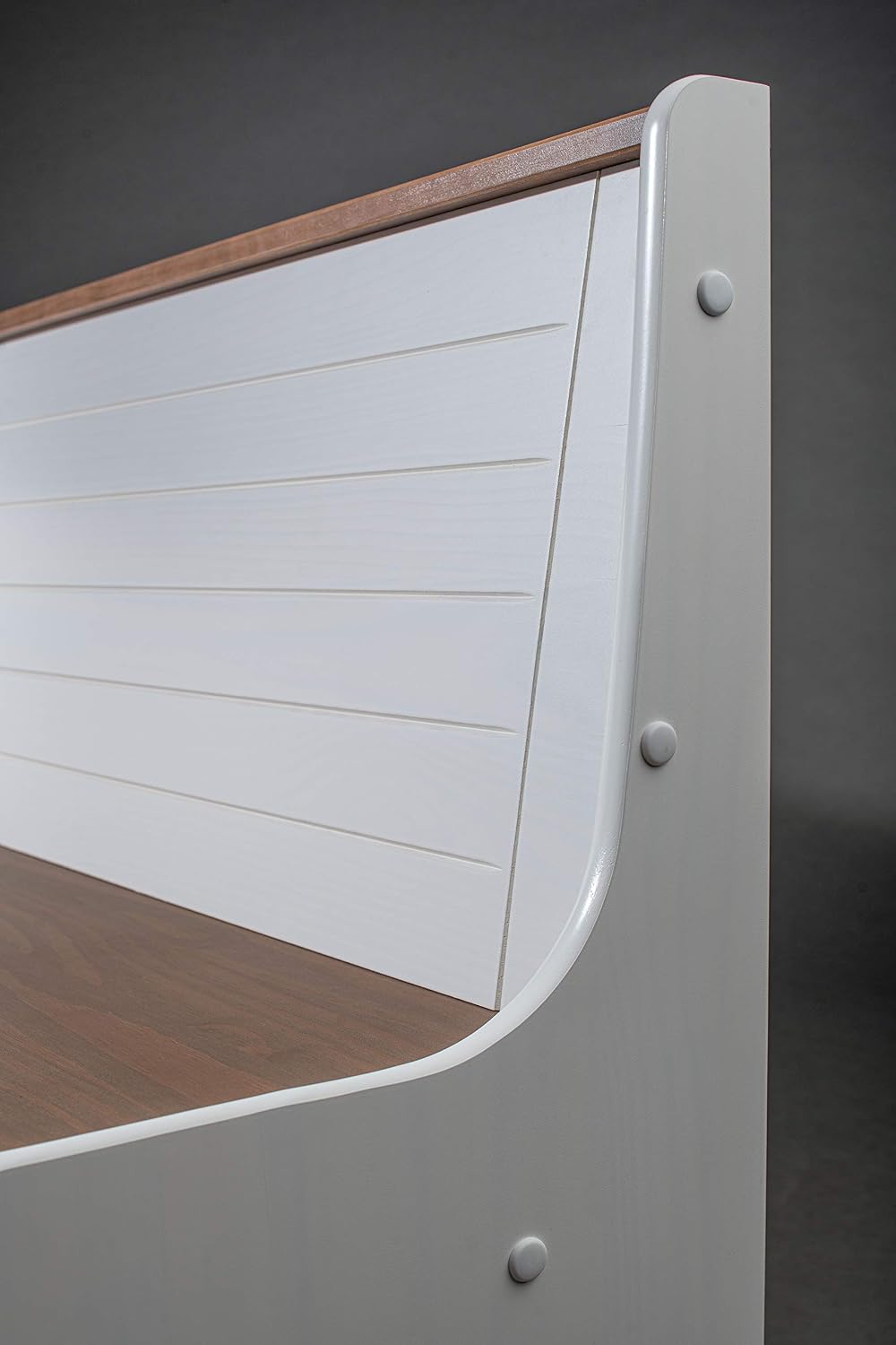 Close-up of the backrest and side panel construction of the Inter Link Westerland 30.2 corner bench, highlighting the white lacquered pine finish and sepia accents.