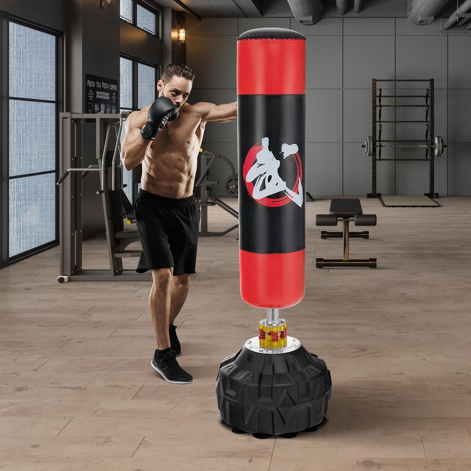 Adult male punching the GYMAX punching bag in a gym setting