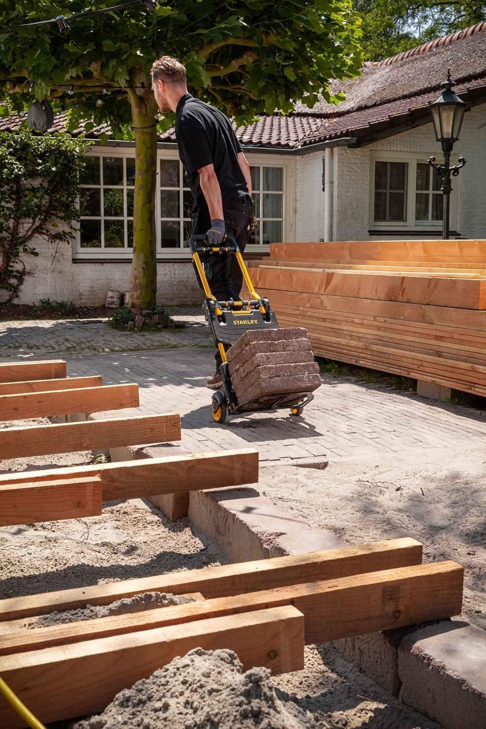 Man pulling Stanley hand truck with heavy load