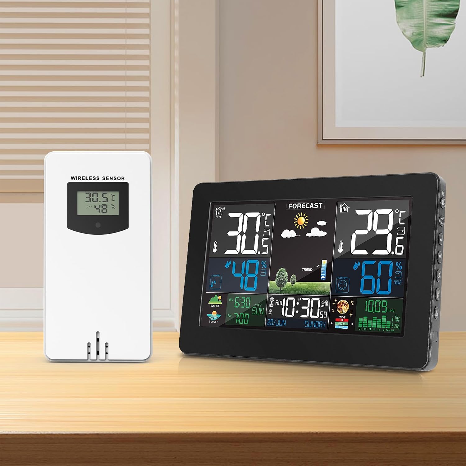 The VOKSUN wireless outdoor sensor placed next to a larger VOKSUN weather station display unit on a wooden table.