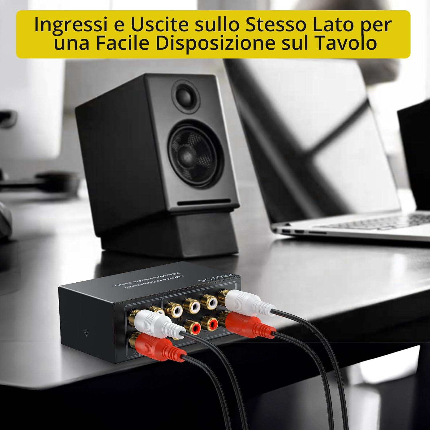 The PROZOR RCA audio switch placed on a desk with RCA cables connected, showing its compact size and convenient port placement.