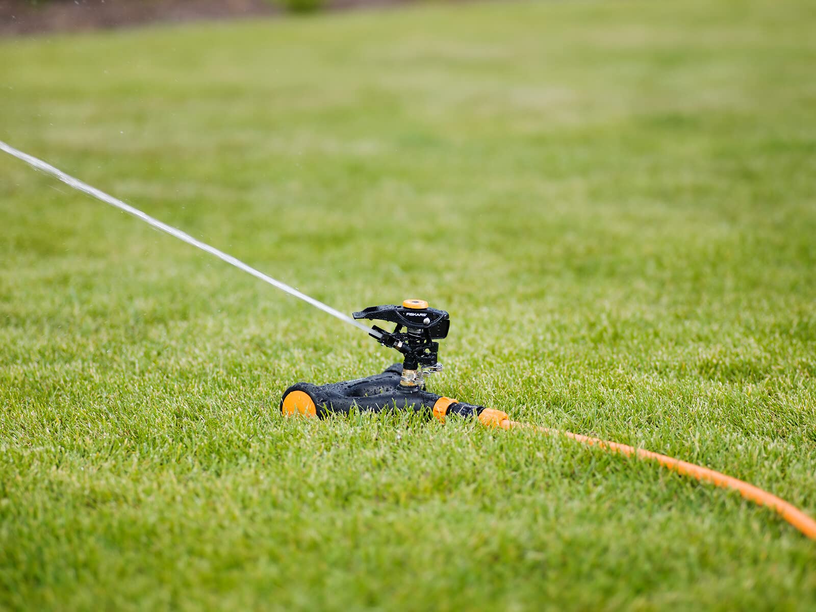 Fiskars Irrigatore a Impulso XL di Metallo con Ruote, Con Distanza | Getto e Rotazione Regolabili, Misura Universale, Portata Ø 26 m, 938 g, Nero/Arancione, 1023656